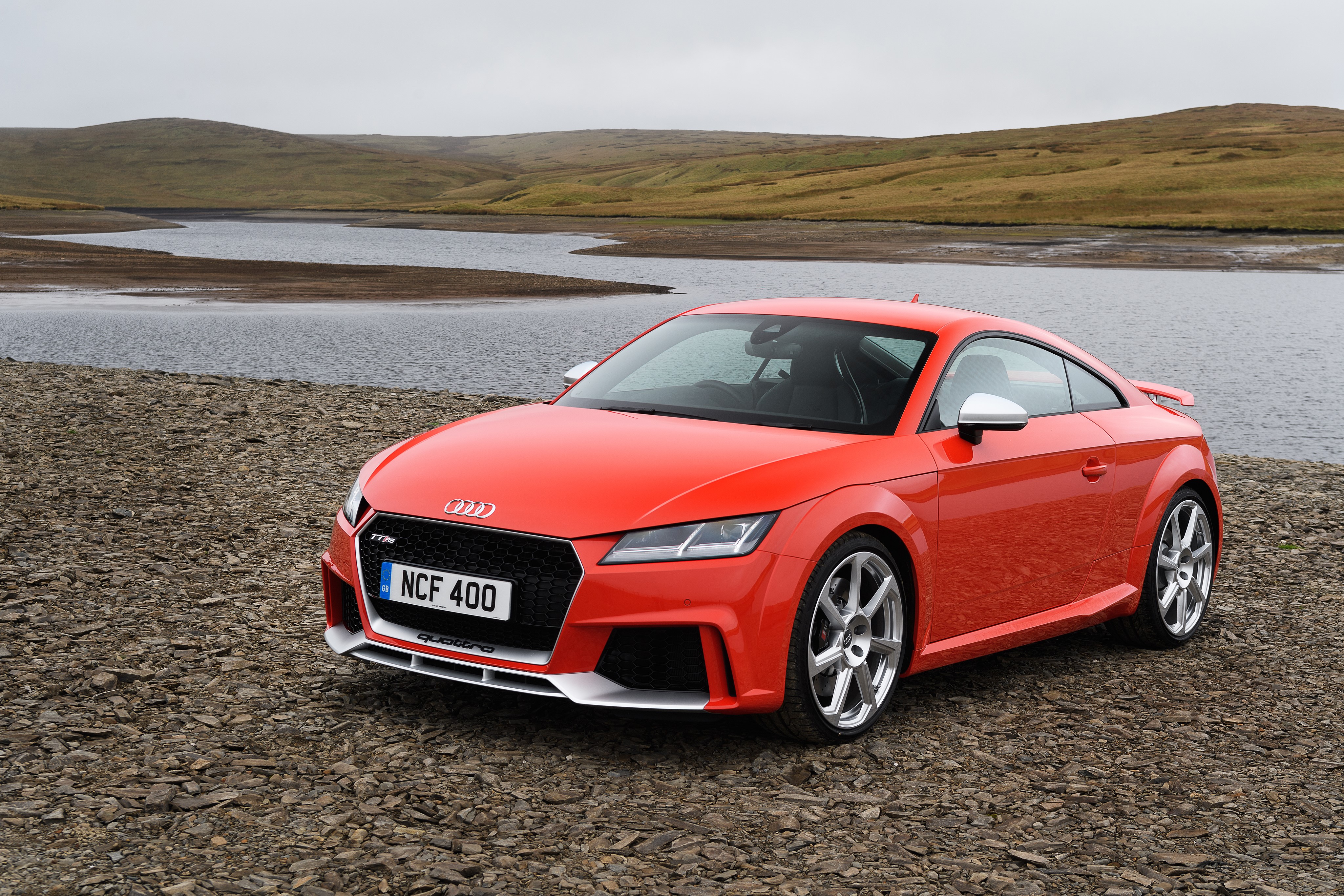 Red Audi TT RS Coupe on rocky shore HD Wallpaper
