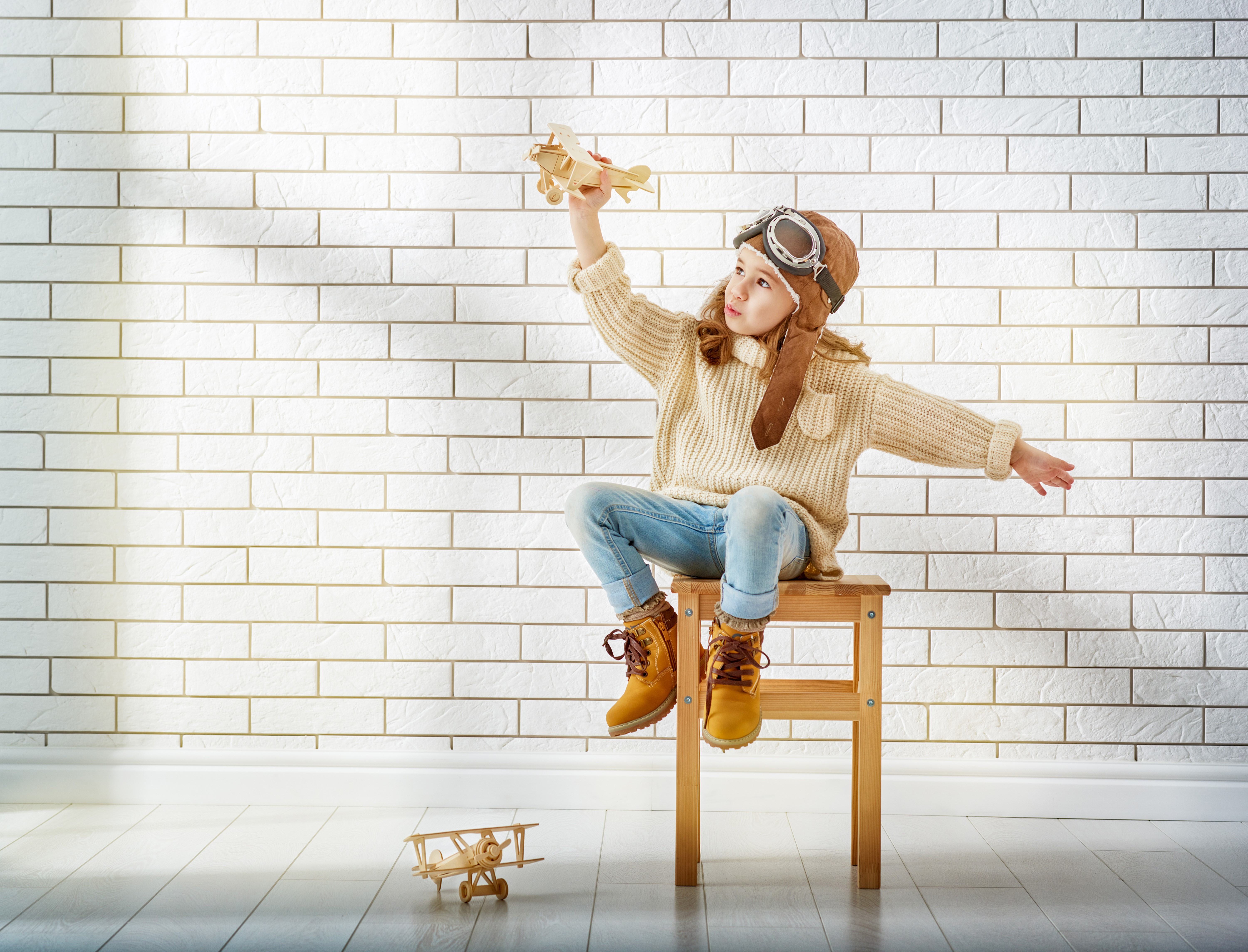 Little girl in pilot costume with toy airplane HD Wallpaper