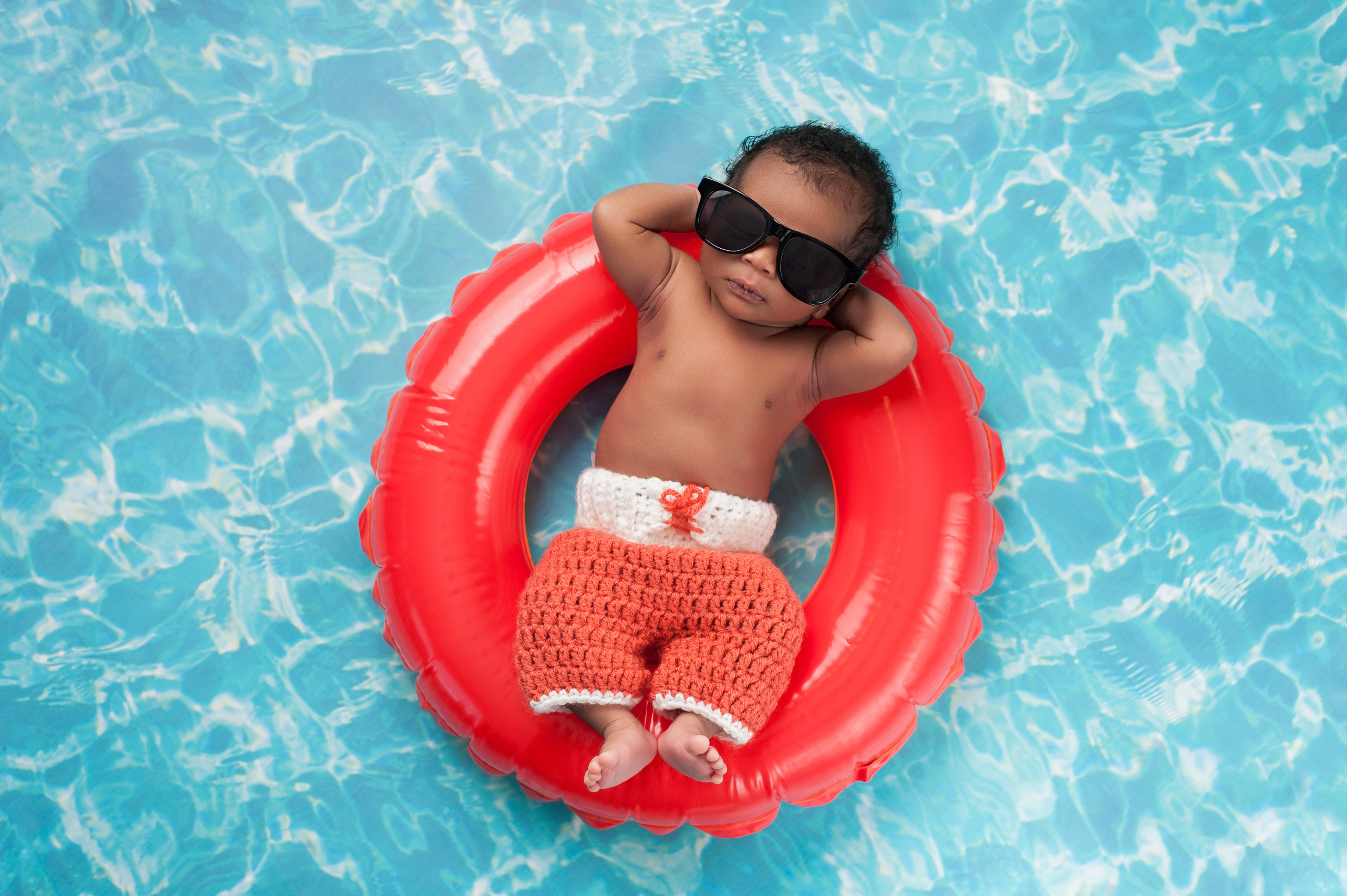 Baby in sunglasses on a float in a pool HD Wallpaper