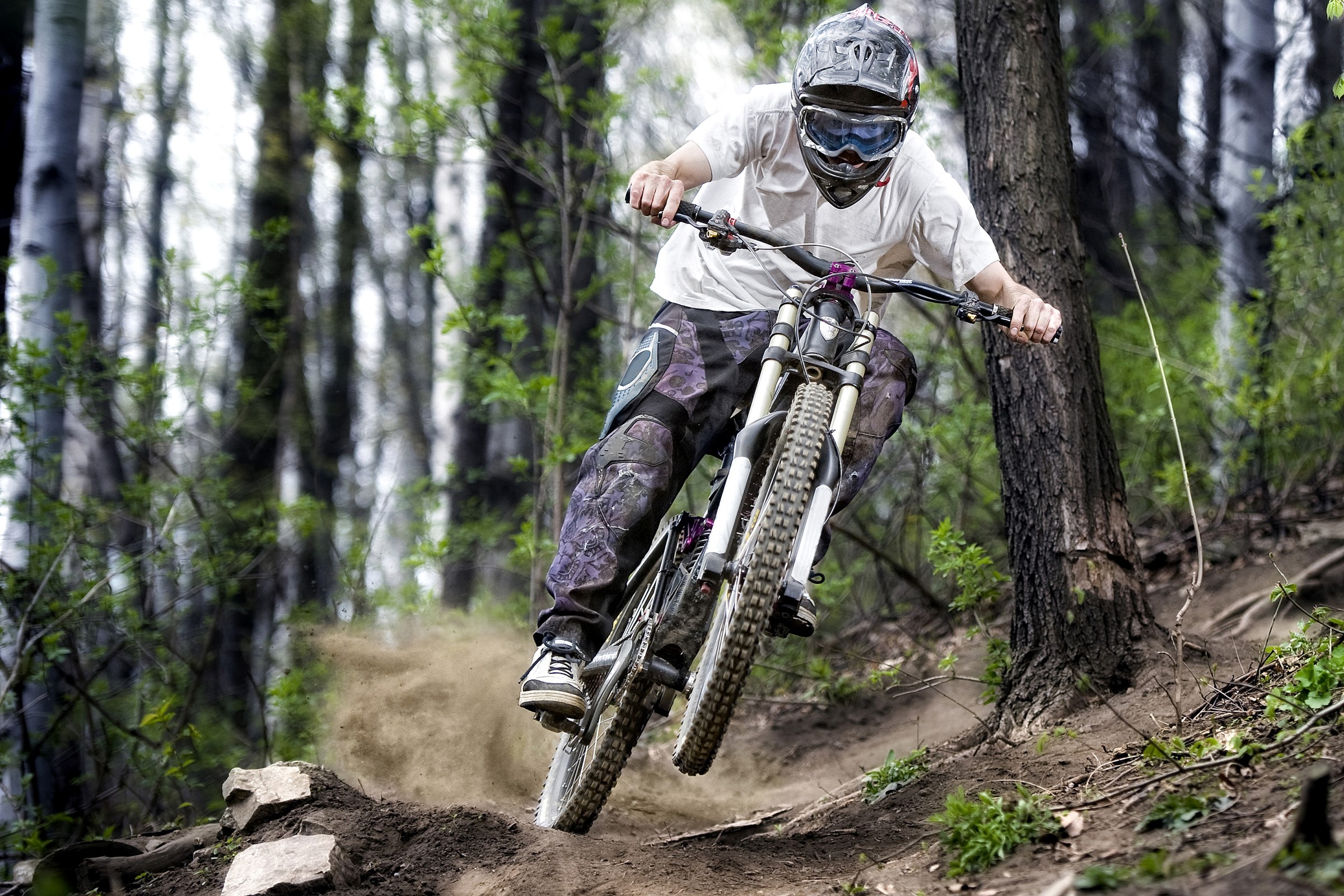 Mountain biker in protective gear riding downhill HD Wallpaper