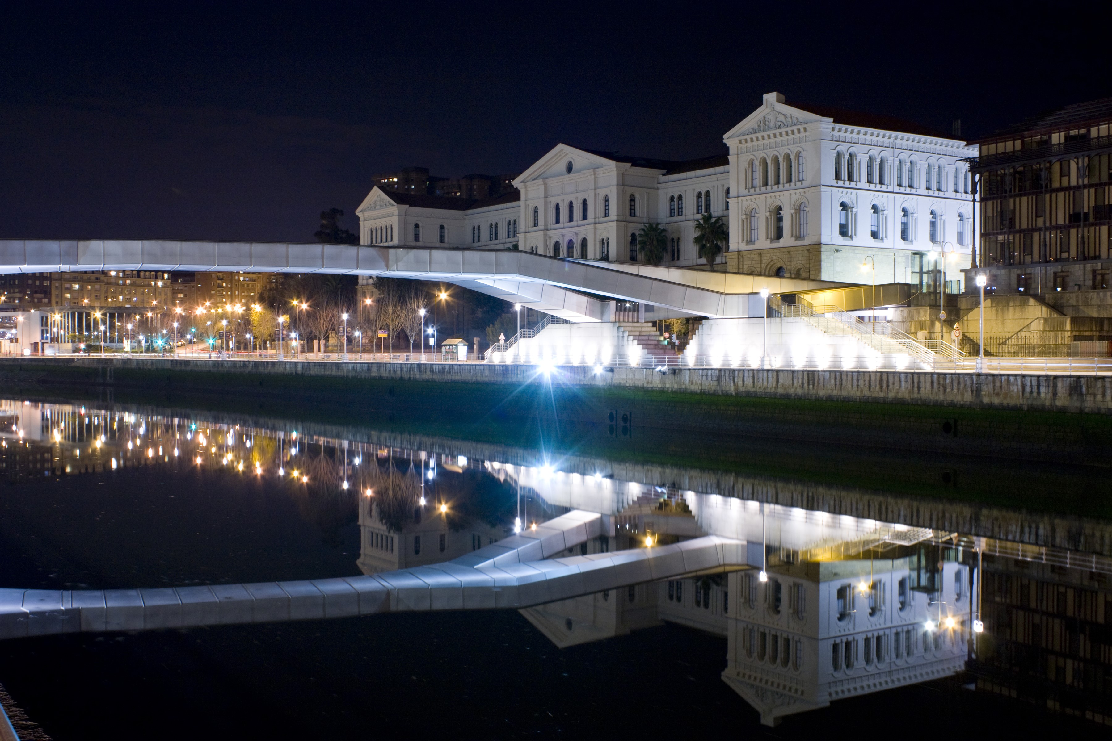 Night view of a bridge and buildings reflected in a canal in Bilbao HD Wallpaper