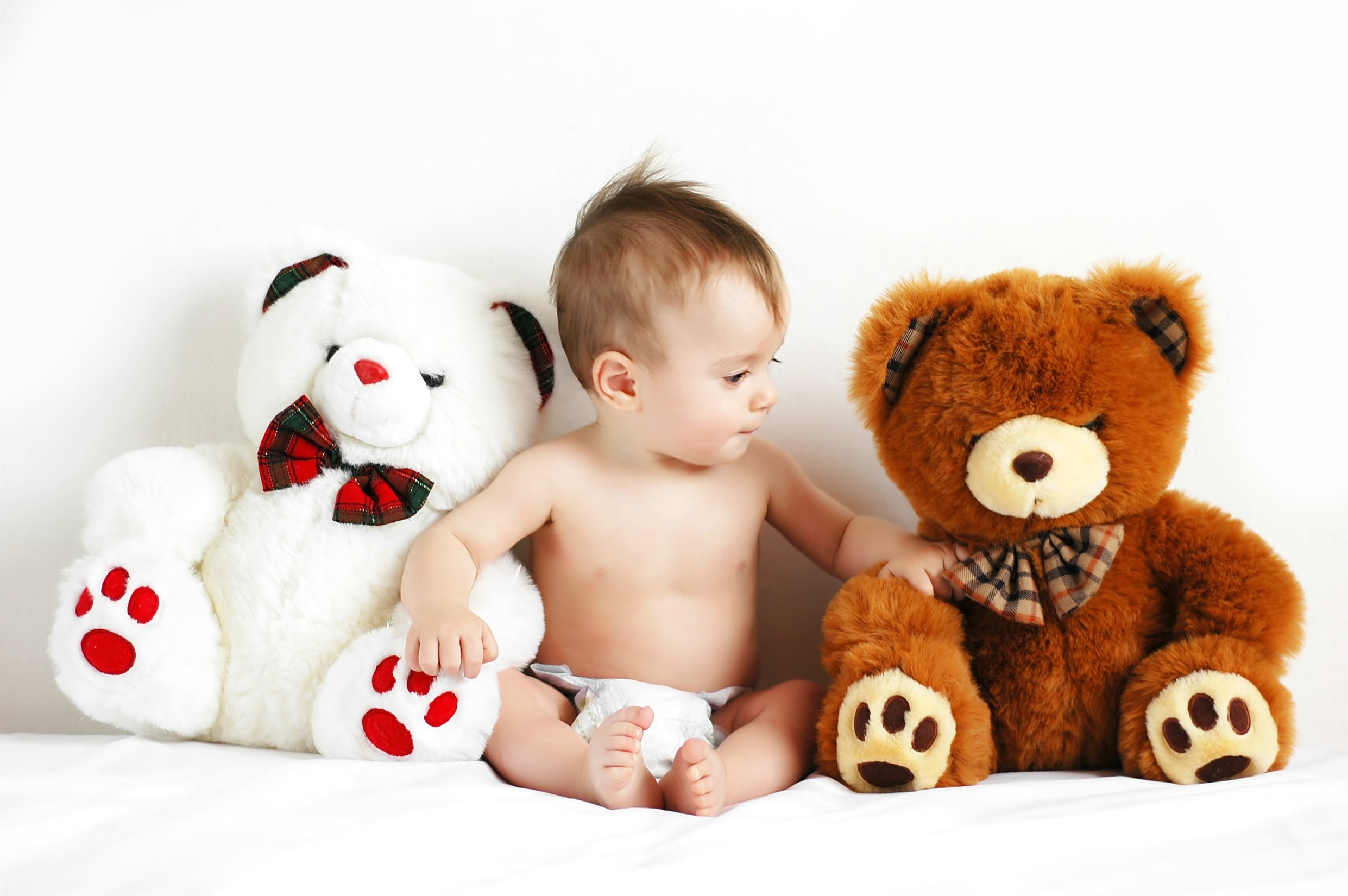 Baby sitting between two teddy bears HD Wallpaper