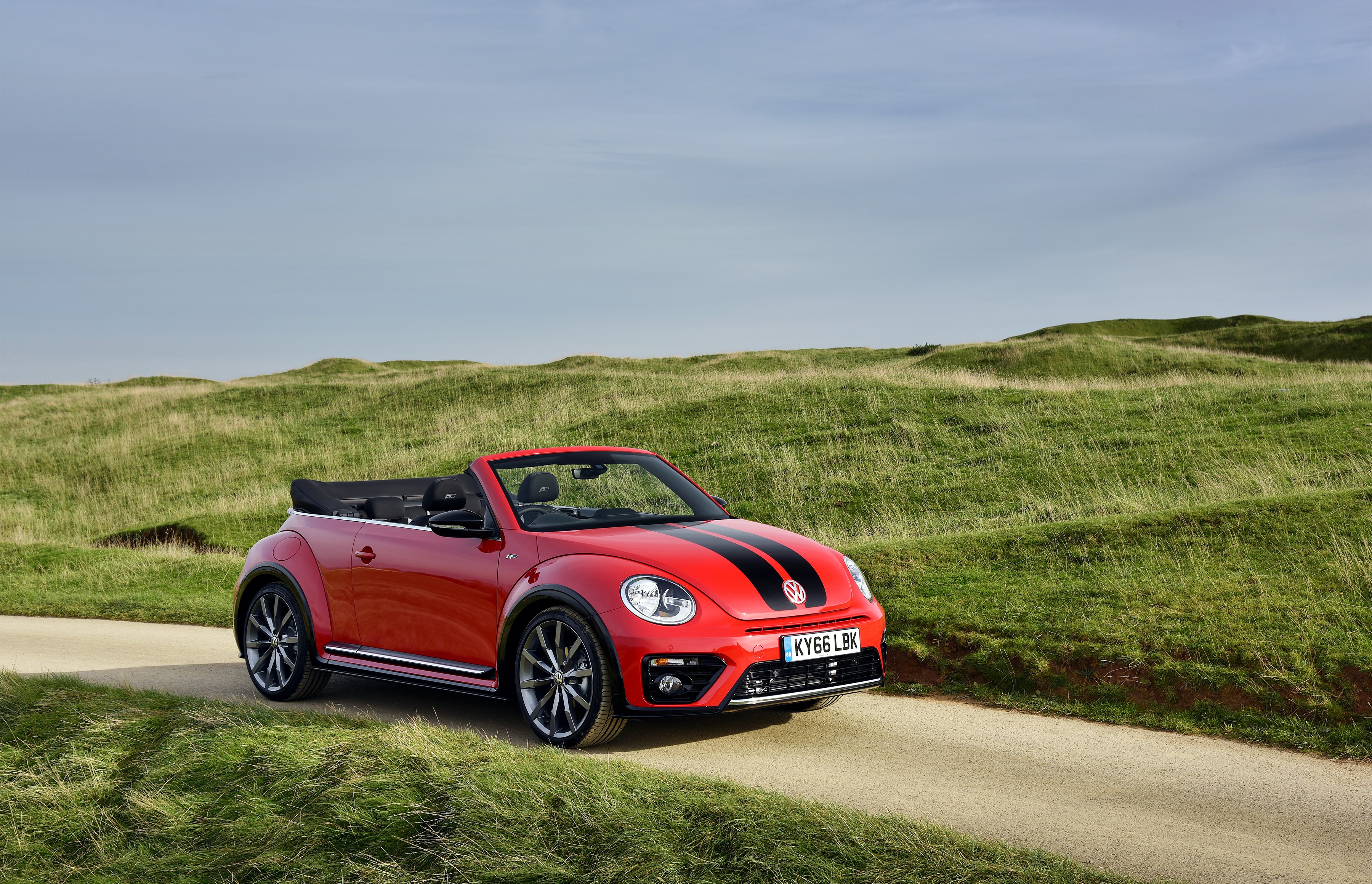 Red Volkswagen Beetle Cabriolet on a dirt road HD Wallpaper