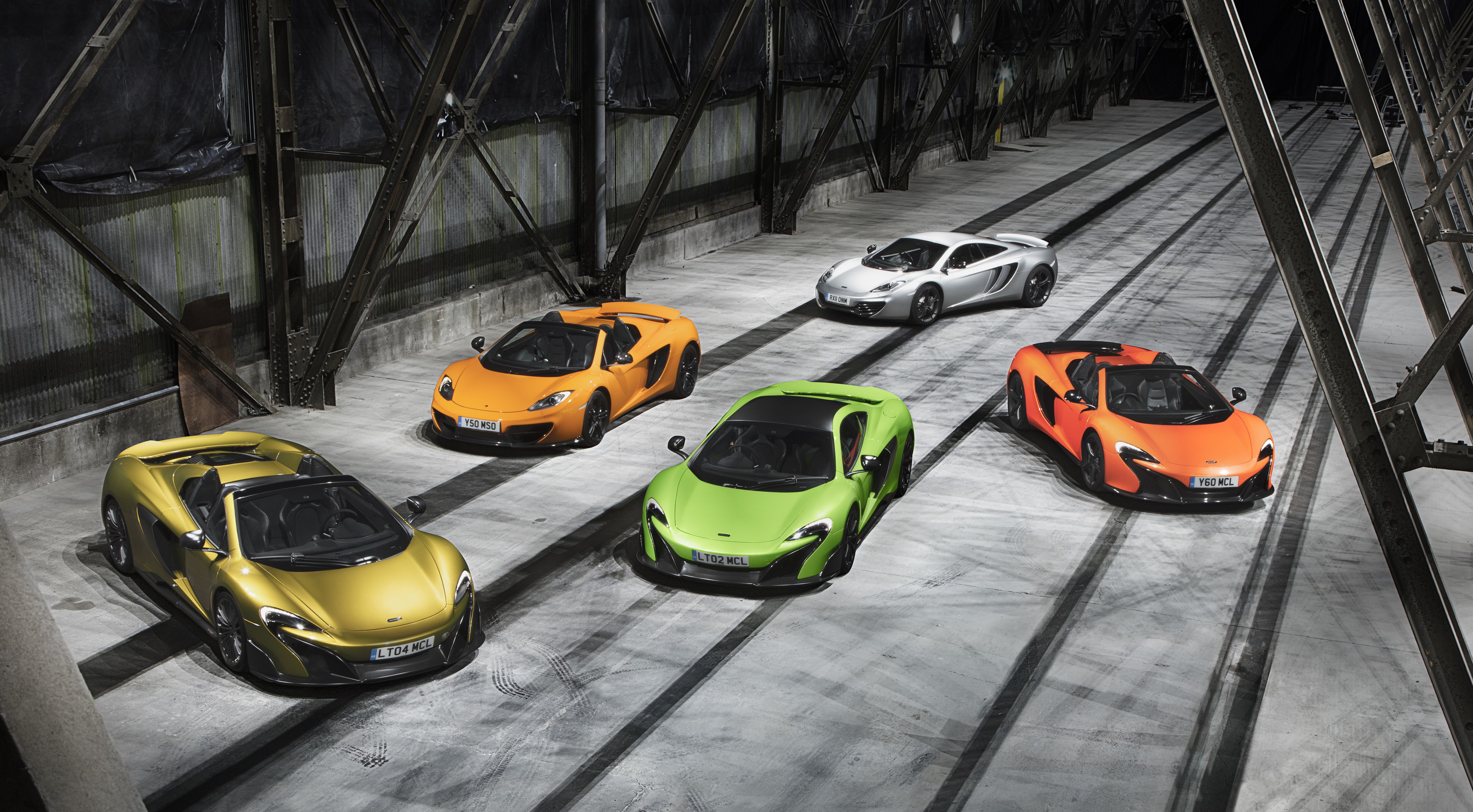 Five McLaren Sports Cars in a Warehouse HD Wallpaper