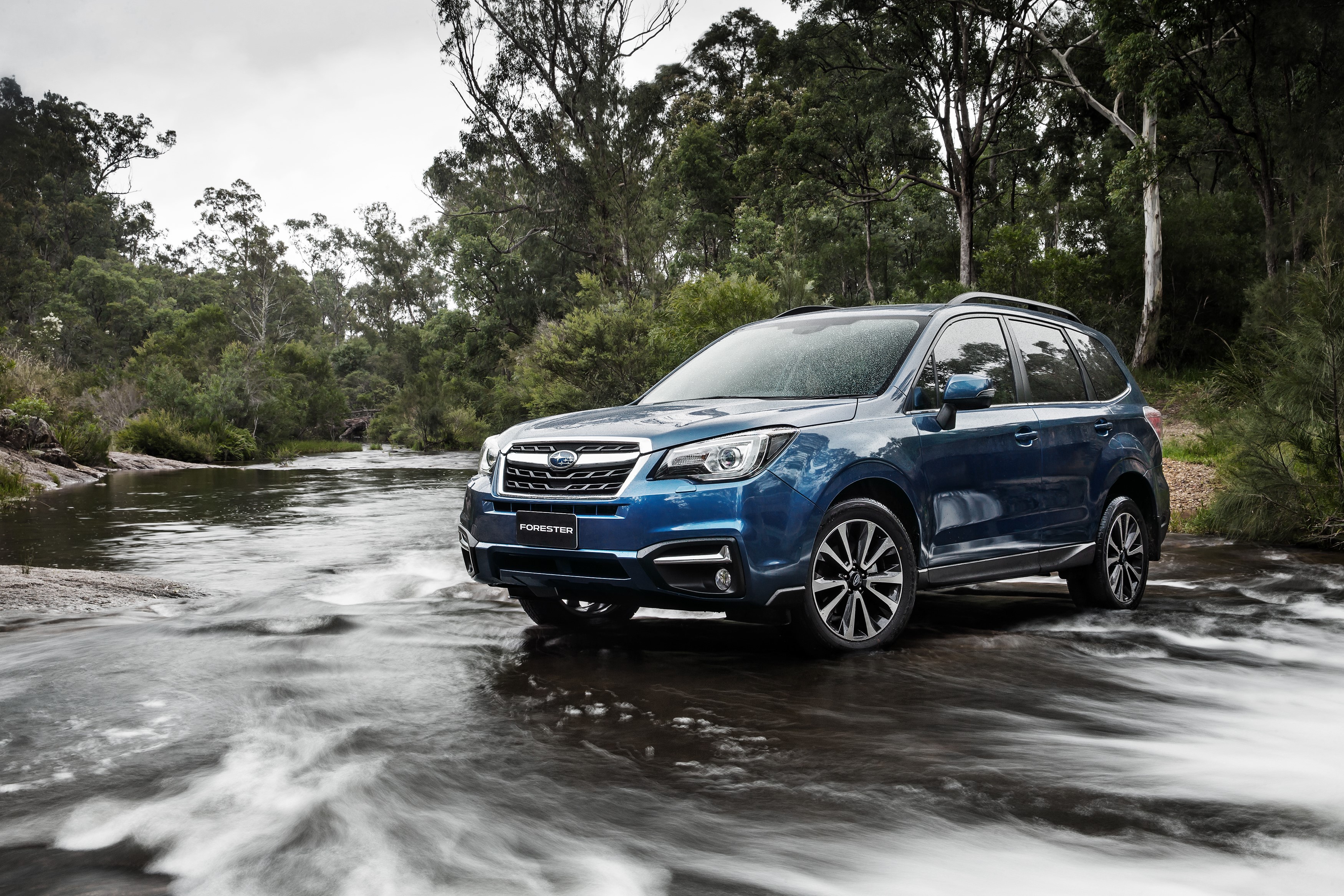 Blue Subaru Forester driving through a stream HD Wallpaper