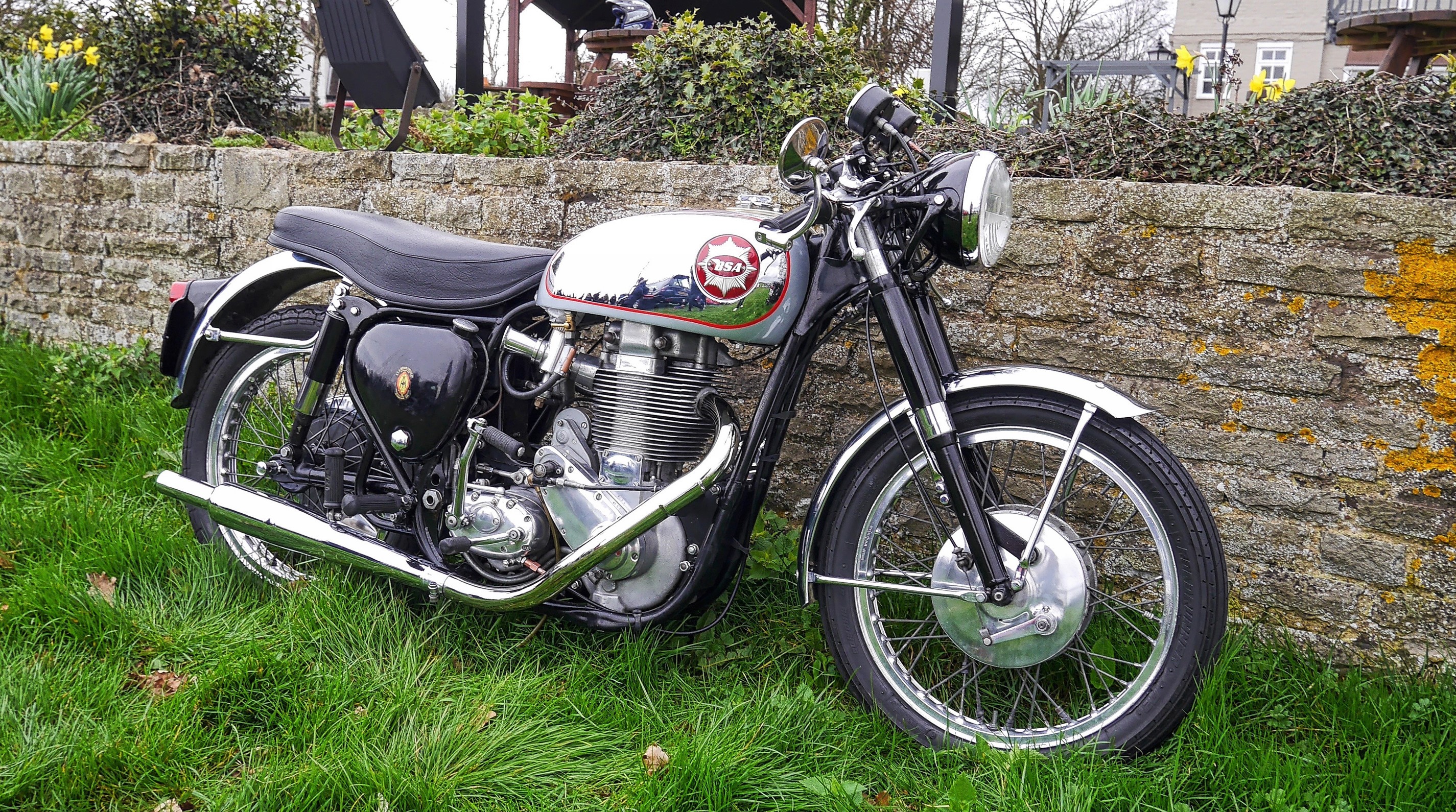 BSA motorcycle parked by a stone wall HD Wallpaper