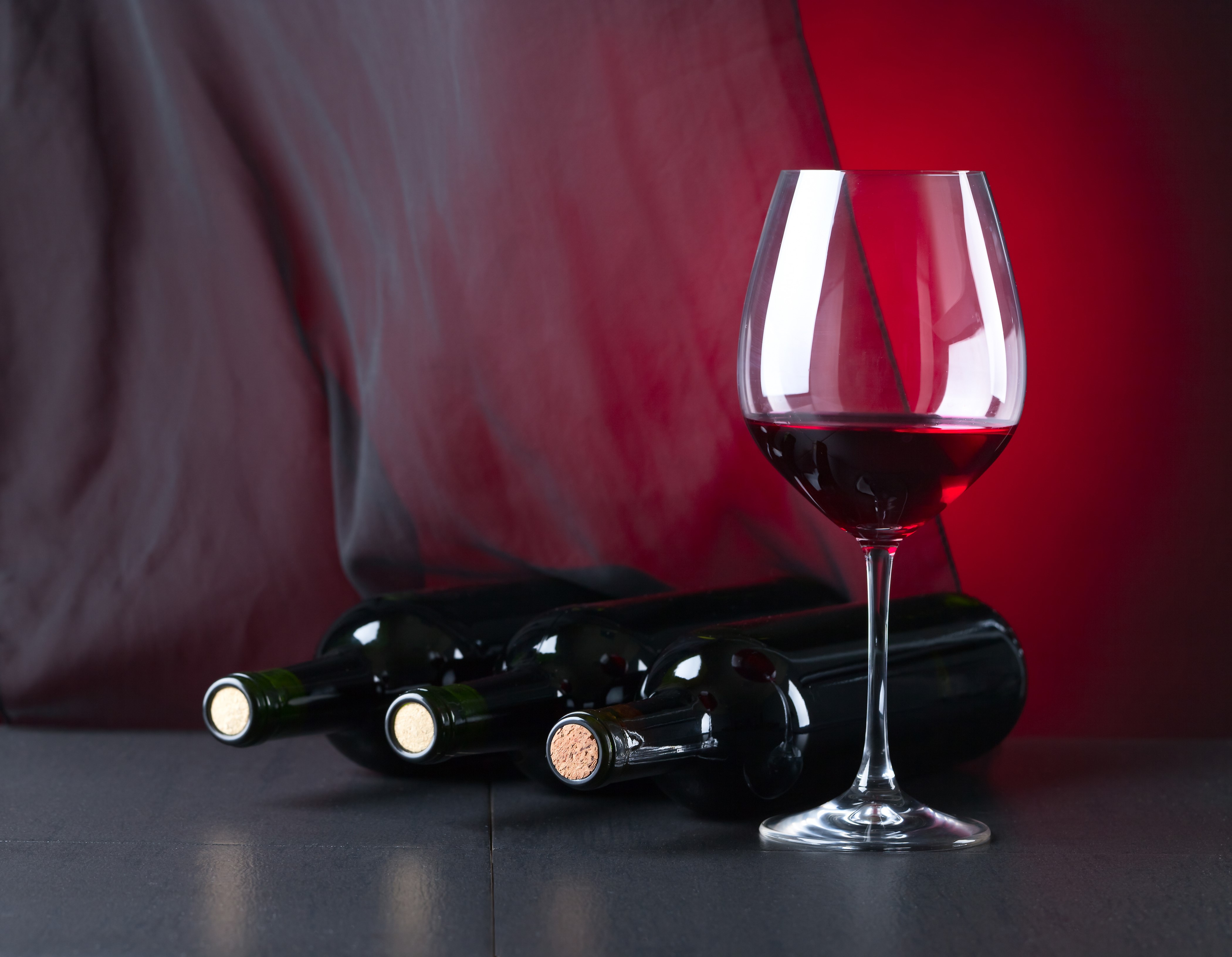 Wine bottles and glass with red background HD Wallpaper
