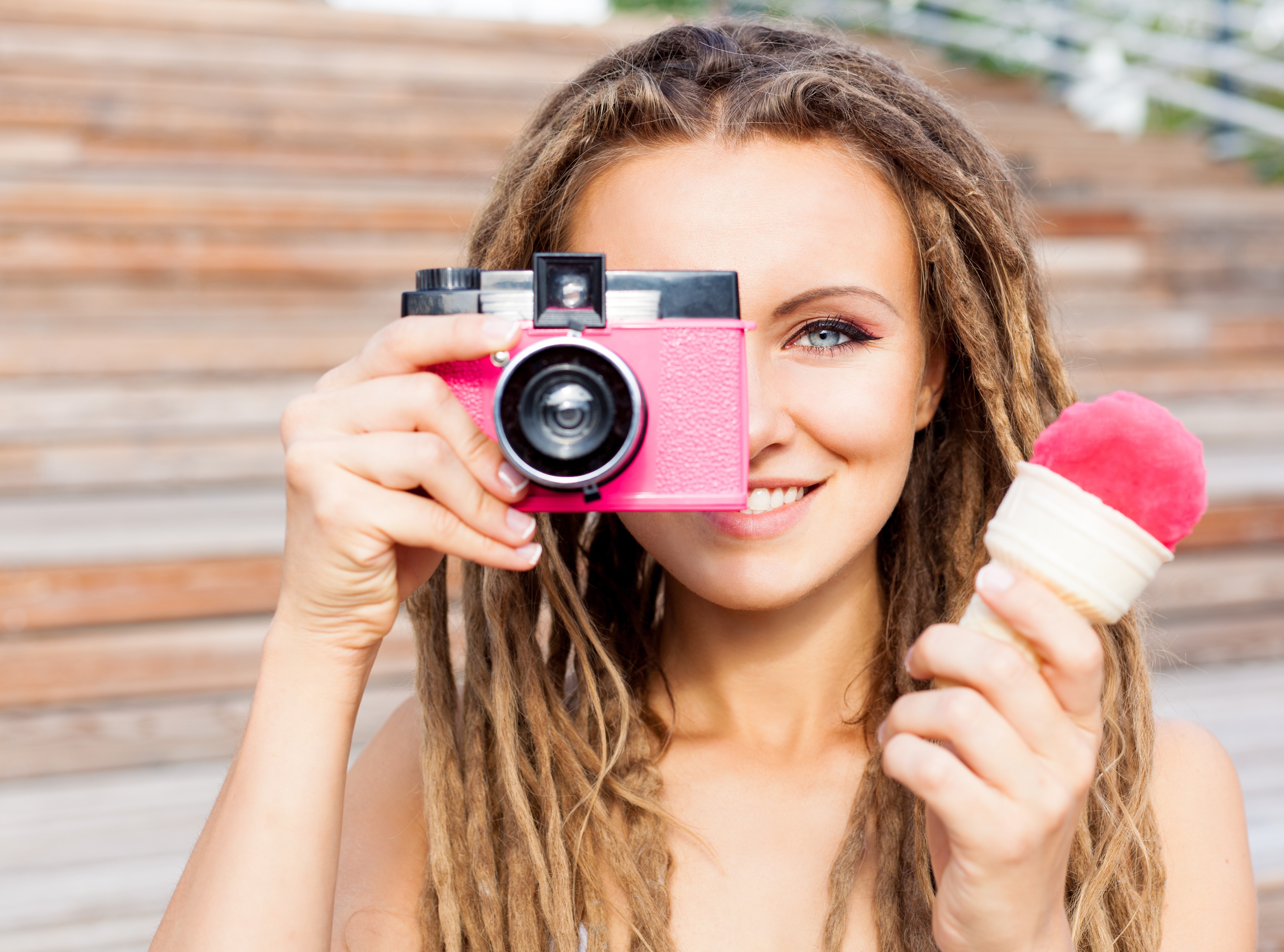 Woman with dreads holding pink camera and ice cream HD Wallpaper