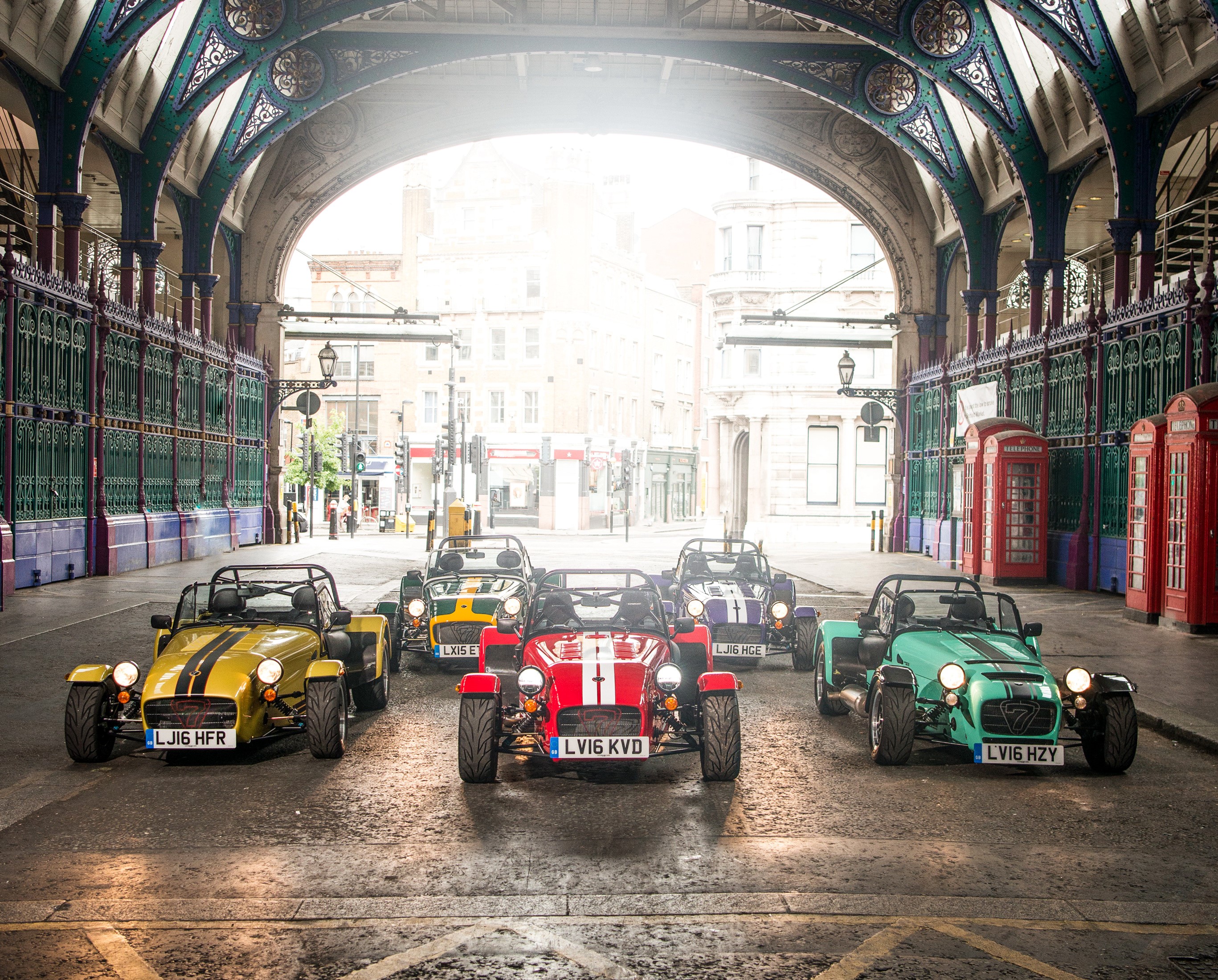 Several Caterham 7 cars lined up on a street HD Wallpaper