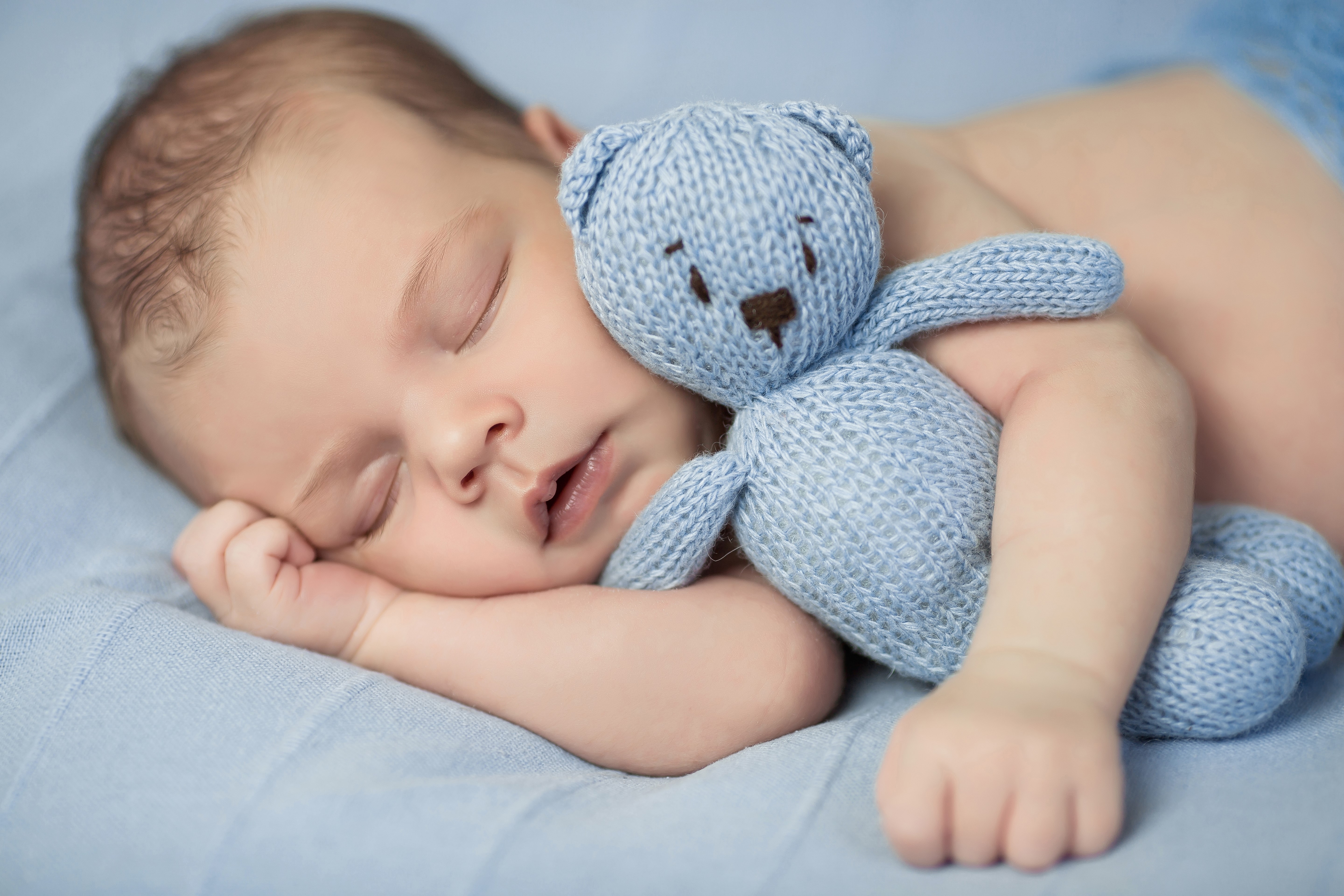 Baby sleeping with a blue teddy bear HD Wallpaper