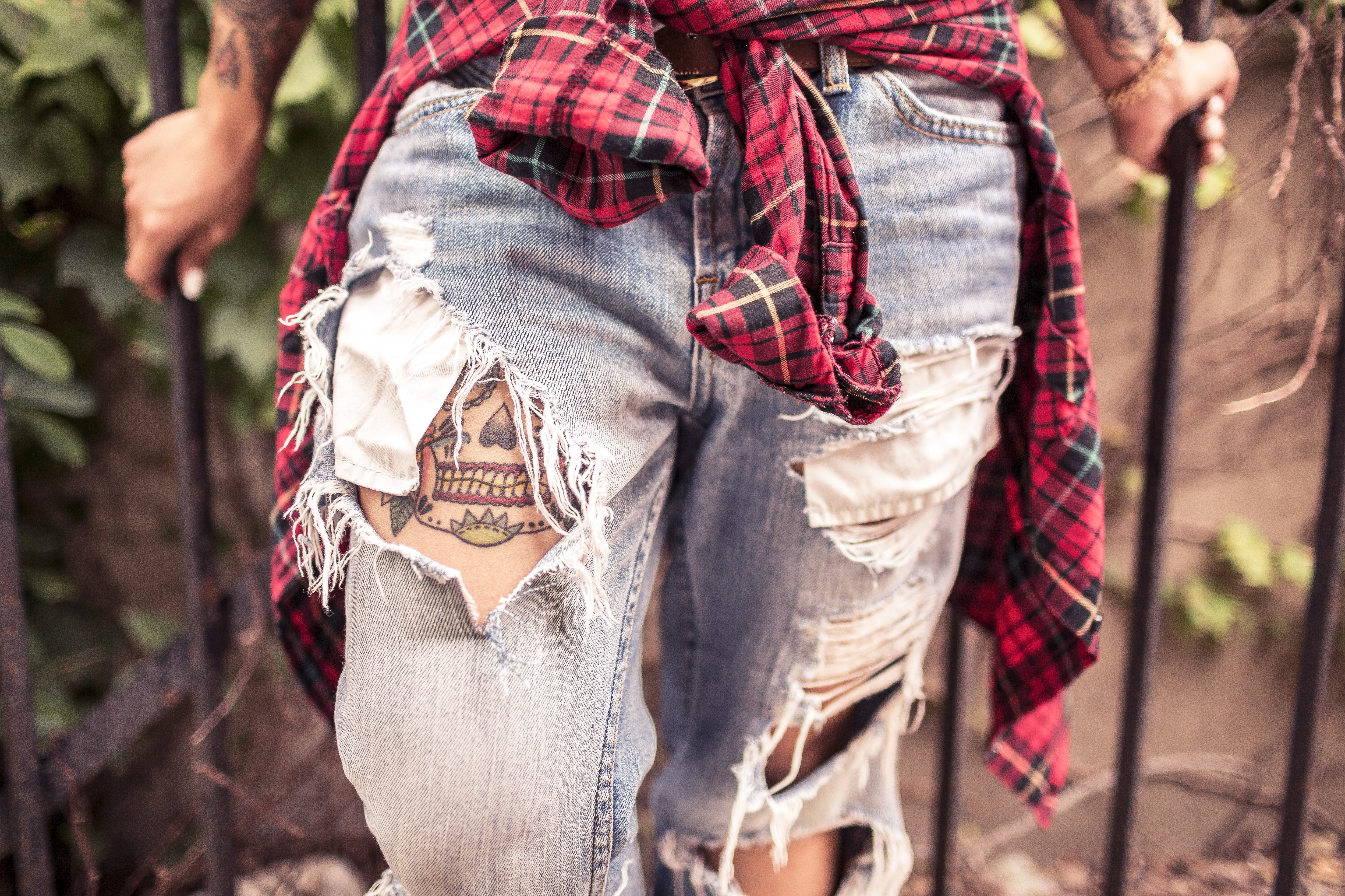 Tattooed legs in ripped jeans with plaid shirt HD Wallpaper