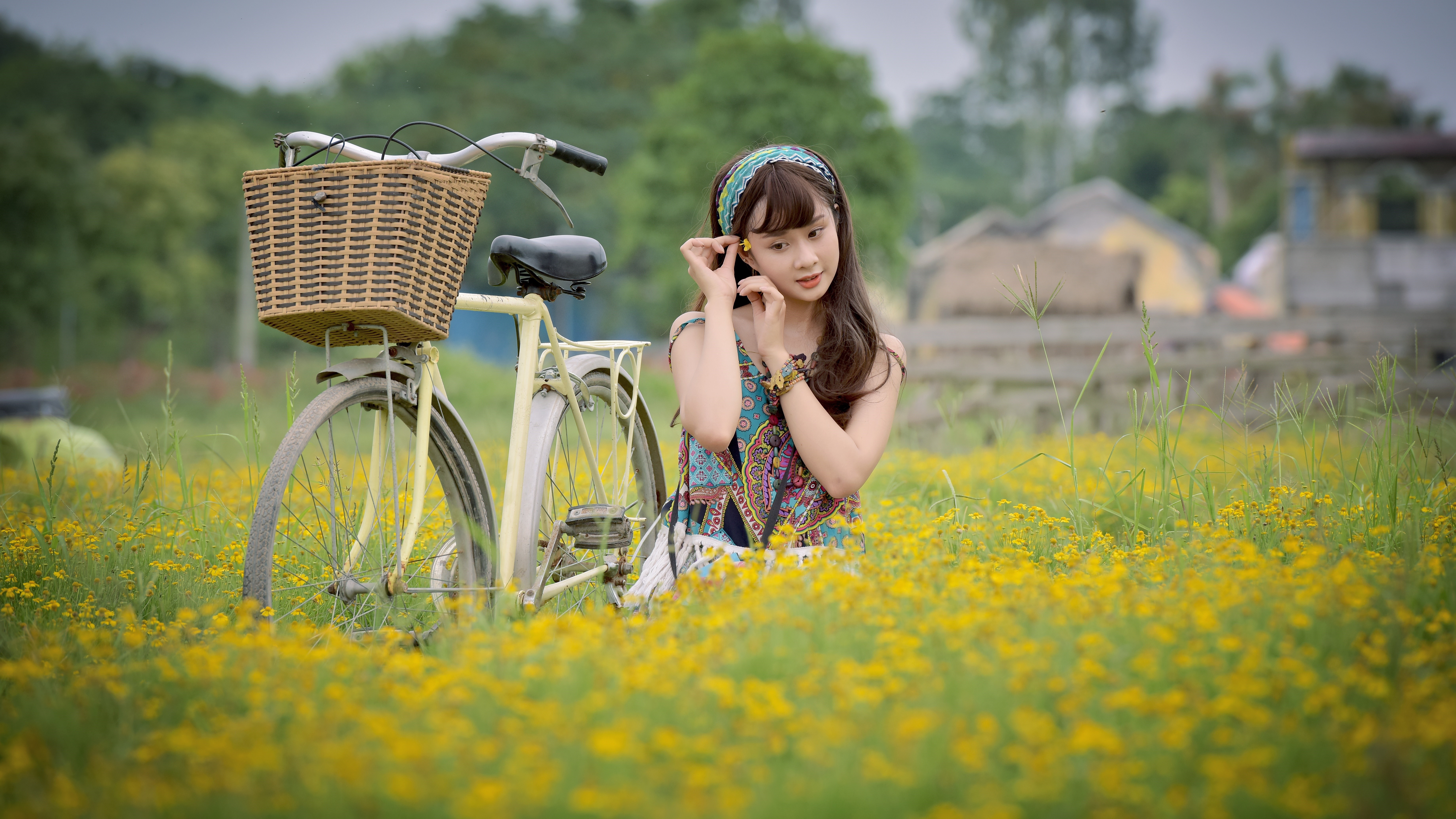 Asian girl with bicycle in a field of yellow flowers HD Wallpaper