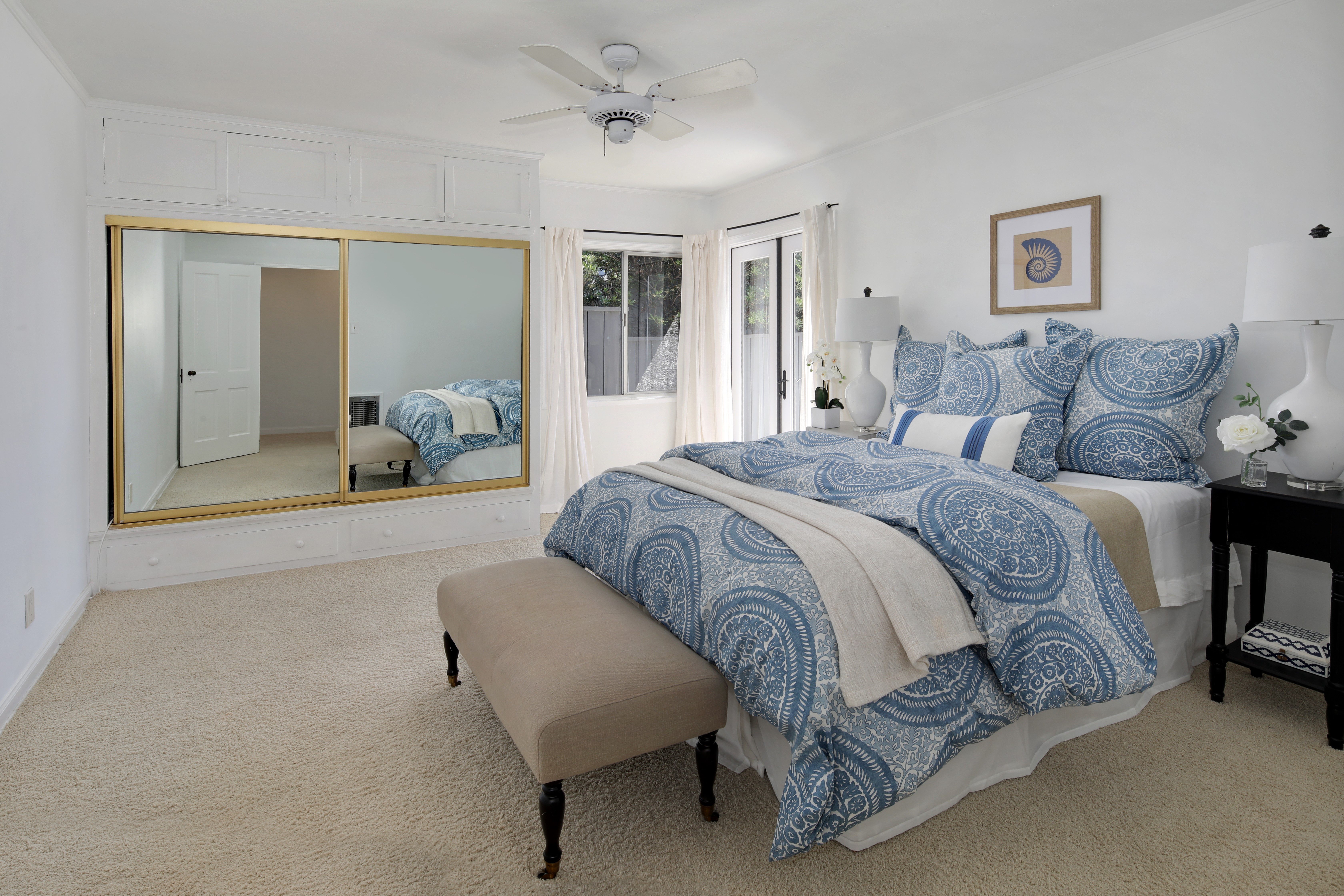 Bedroom with mirrored closet and blue patterned bedding HD Wallpaper