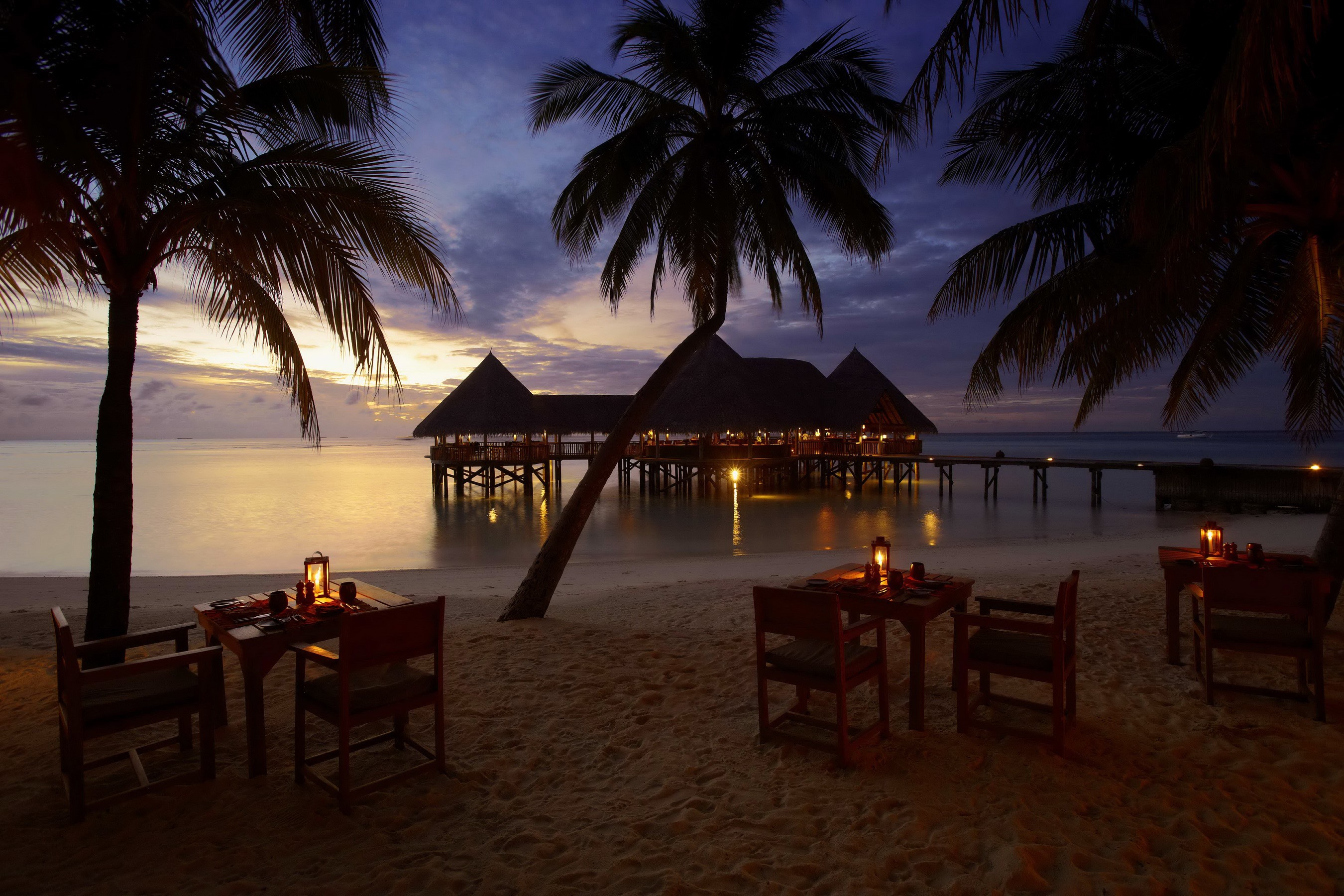 Beachside dining at Gili Lankanfushi, Maldives at dusk HD Wallpaper