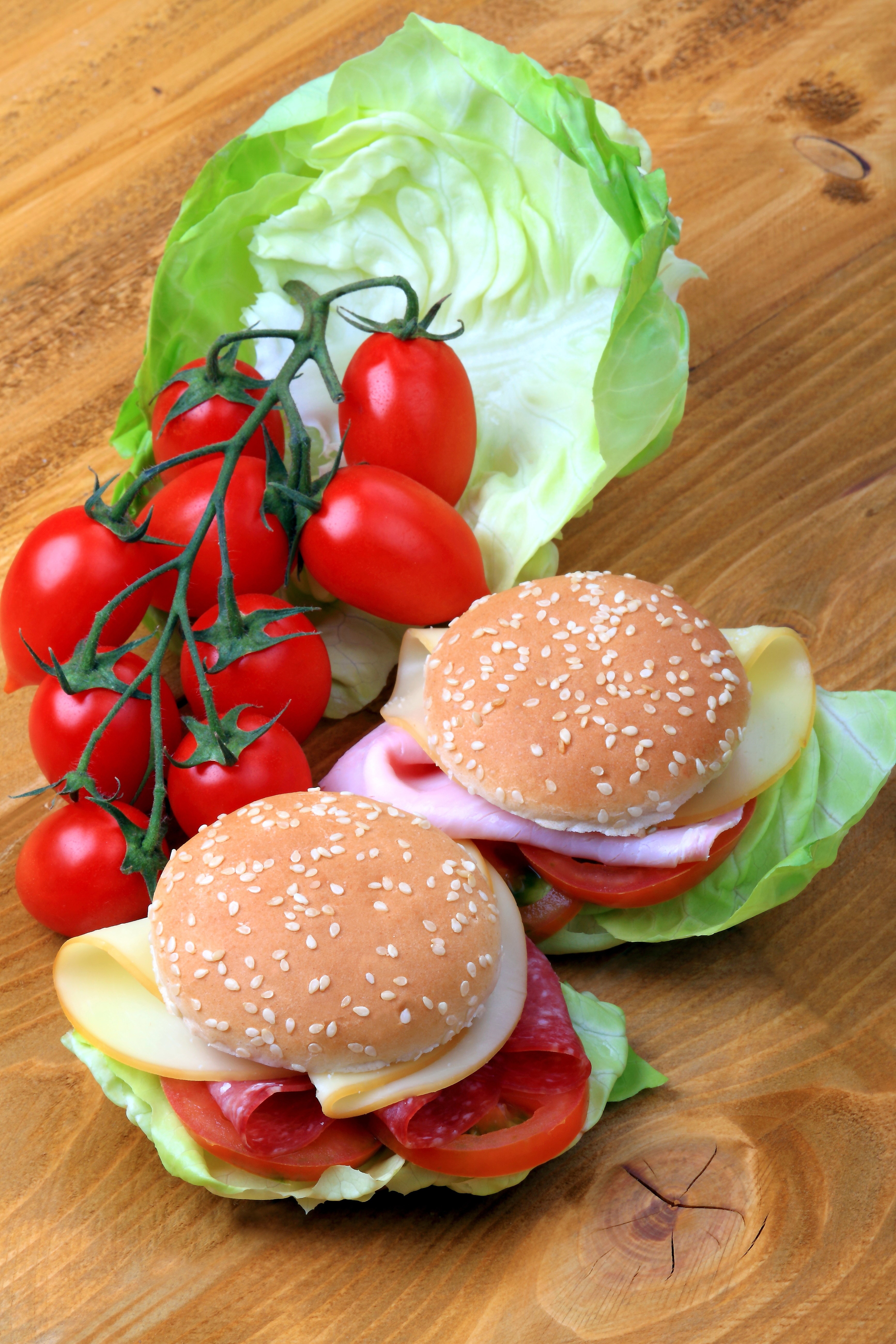 Two mini burgers with tomatoes, lettuce, cheese, and salami HD Phone Wallpaper
