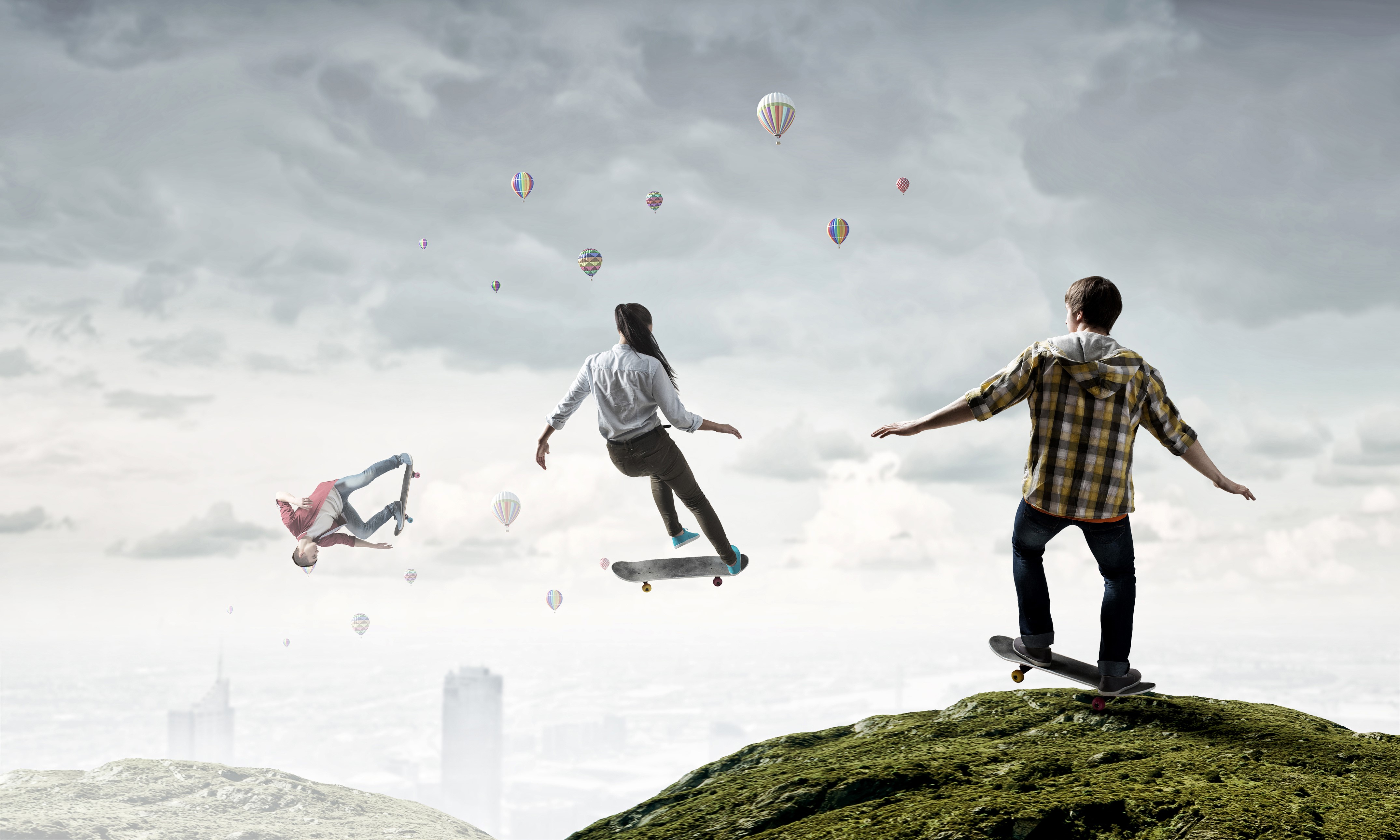 Three people skateboarding and jumping in the sky with hot air balloons HD Wallpaper