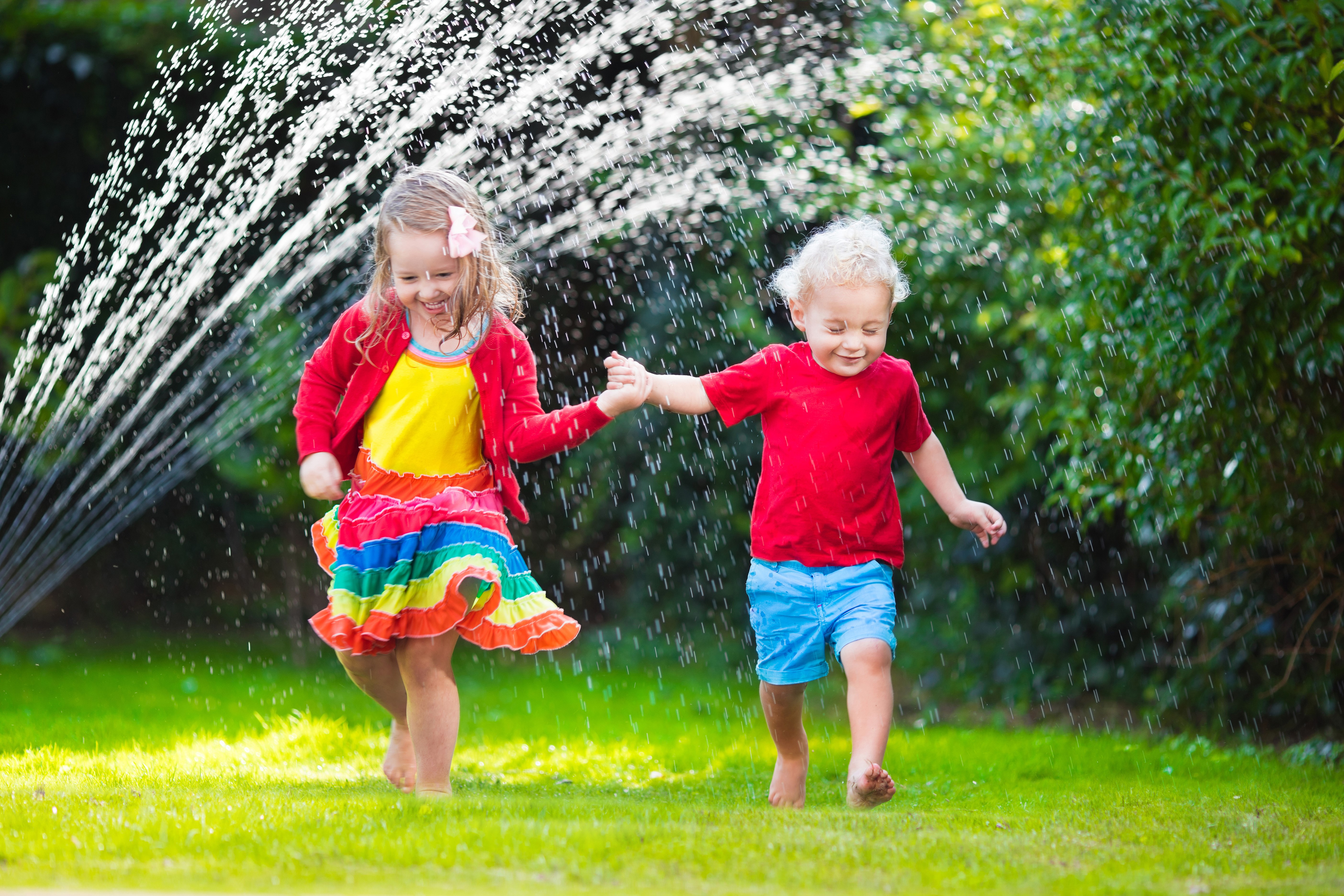 Two children playing in water splash HD Wallpaper