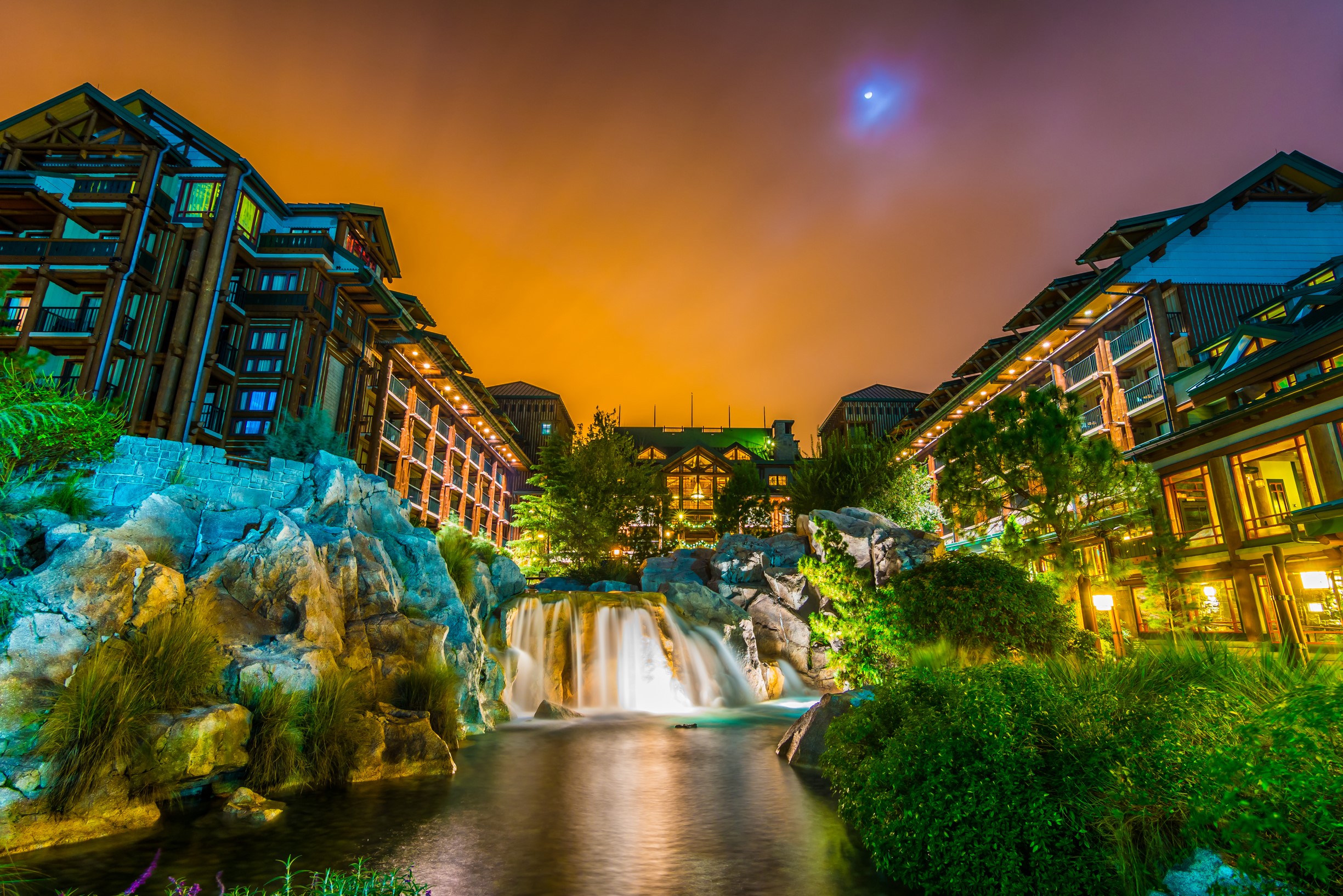 Resort with waterfalls and rocky landscape at night HD Wallpaper
