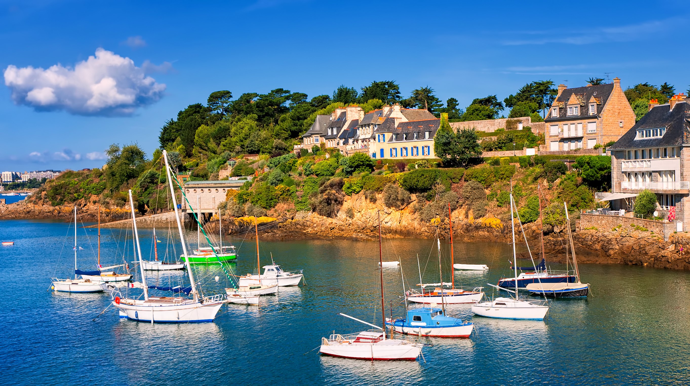 Sailboats in a harbor with houses on a hill in Brittany, France HD Wallpaper