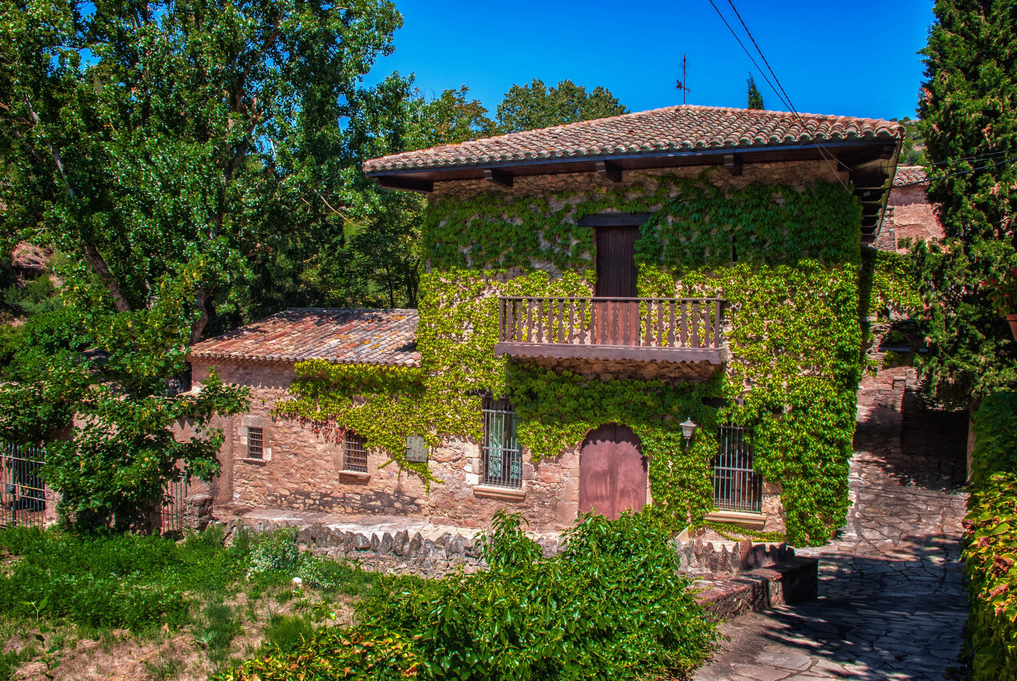 Stone house covered in ivy in Mura, Catalonia, Spain HD Wallpaper