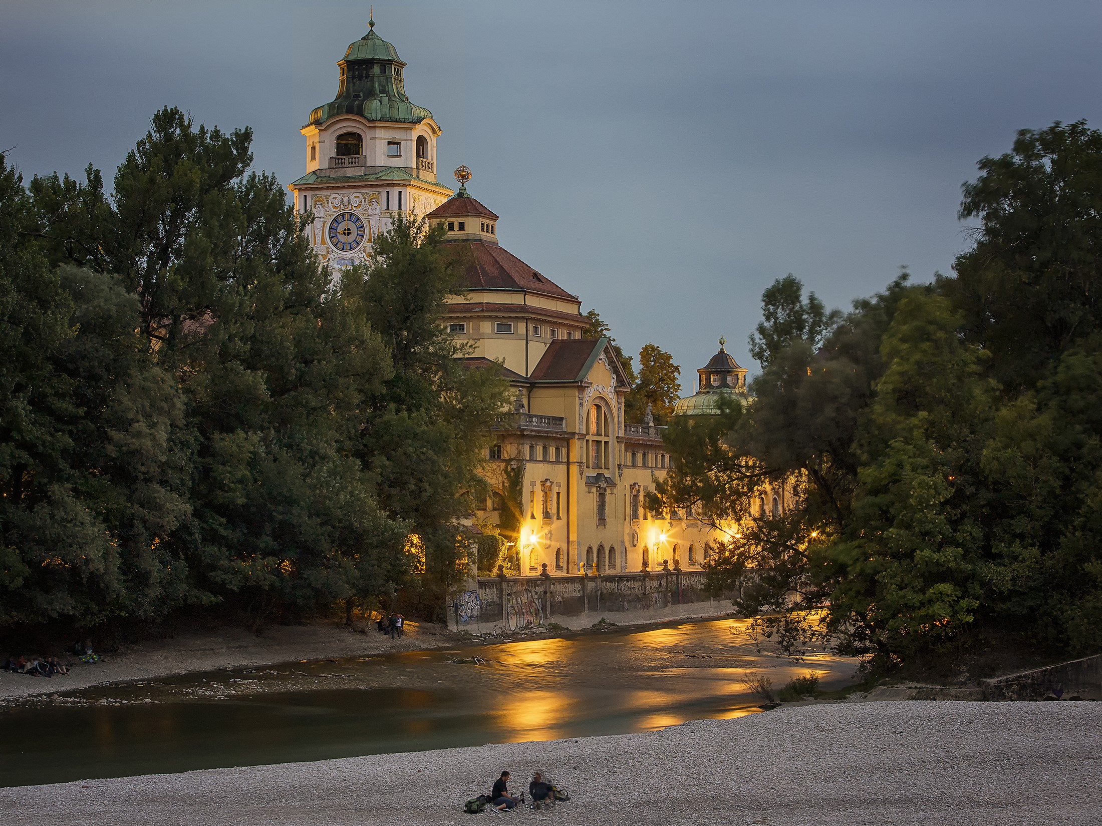 Building with clock tower by river at dusk in Munich HD Wallpaper