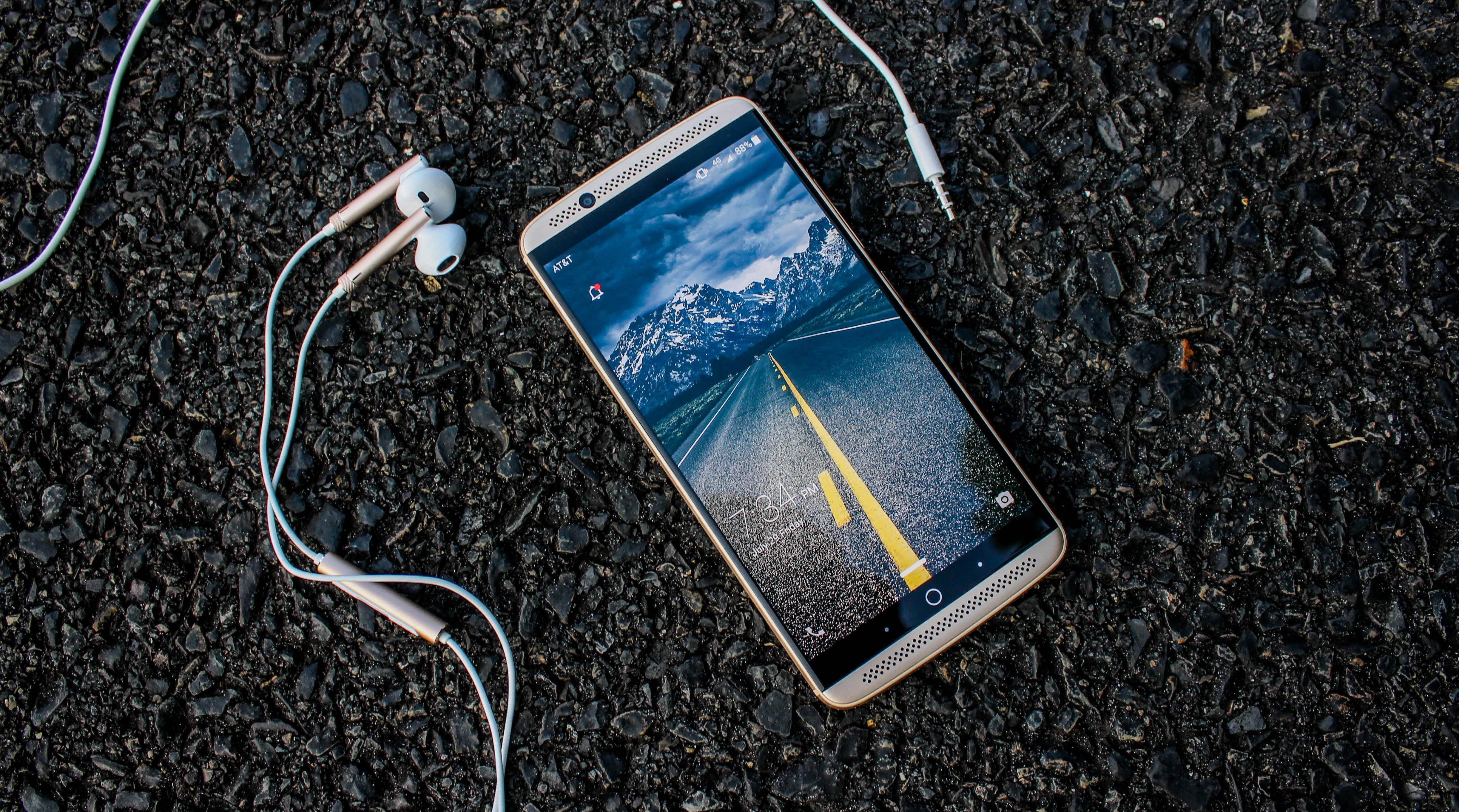 ZTE Gigabit Smartphone with Headphones on Asphalt HD Wallpaper