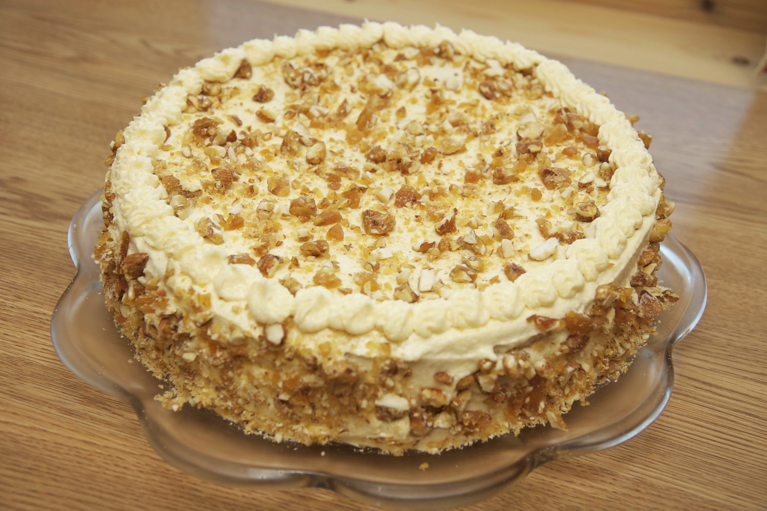 Round cake with cream and nuts on a plate HD Wallpaper
