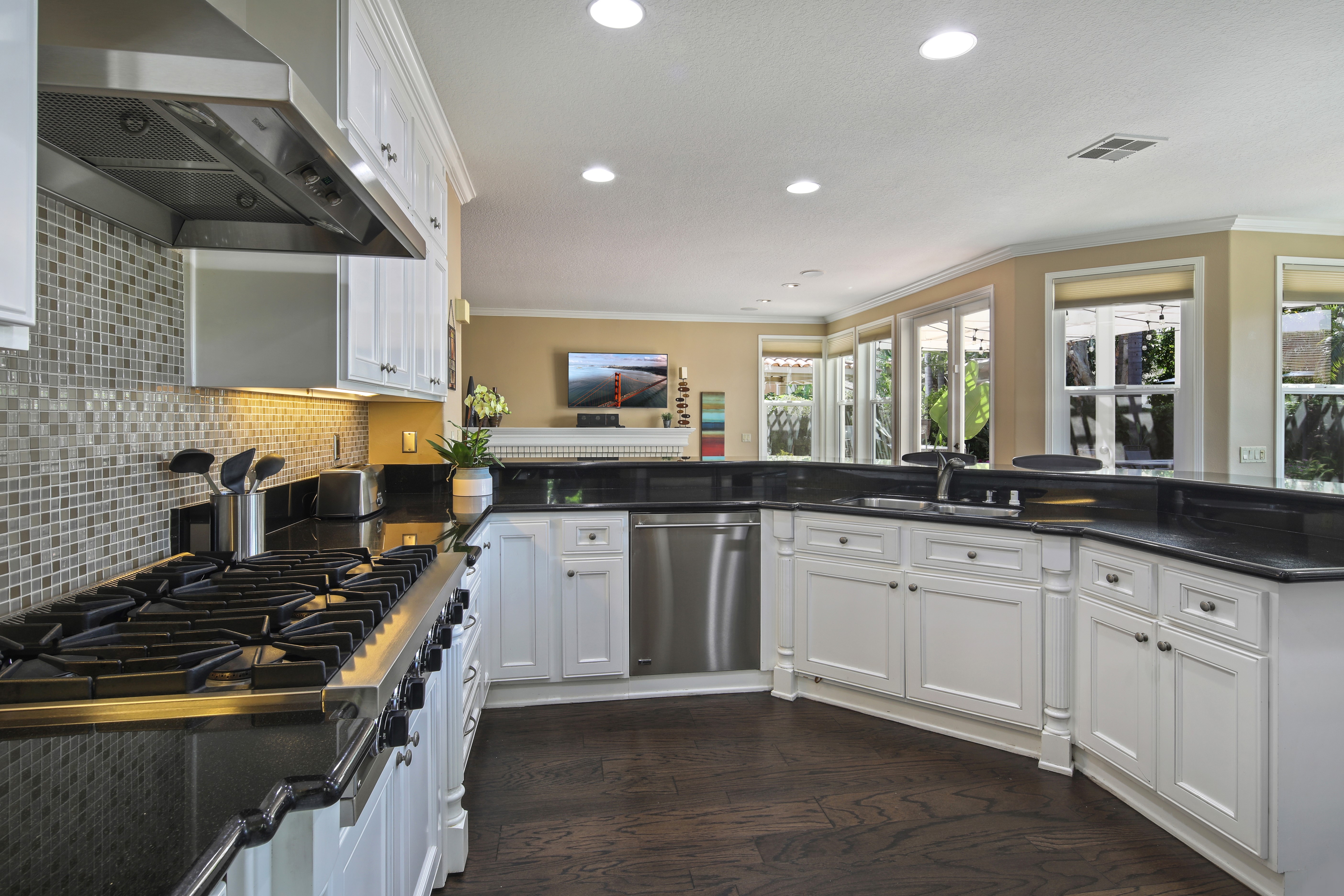 Modern Kitchen with Stainless Steel Appliances and Dark Countertops HD Wallpaper