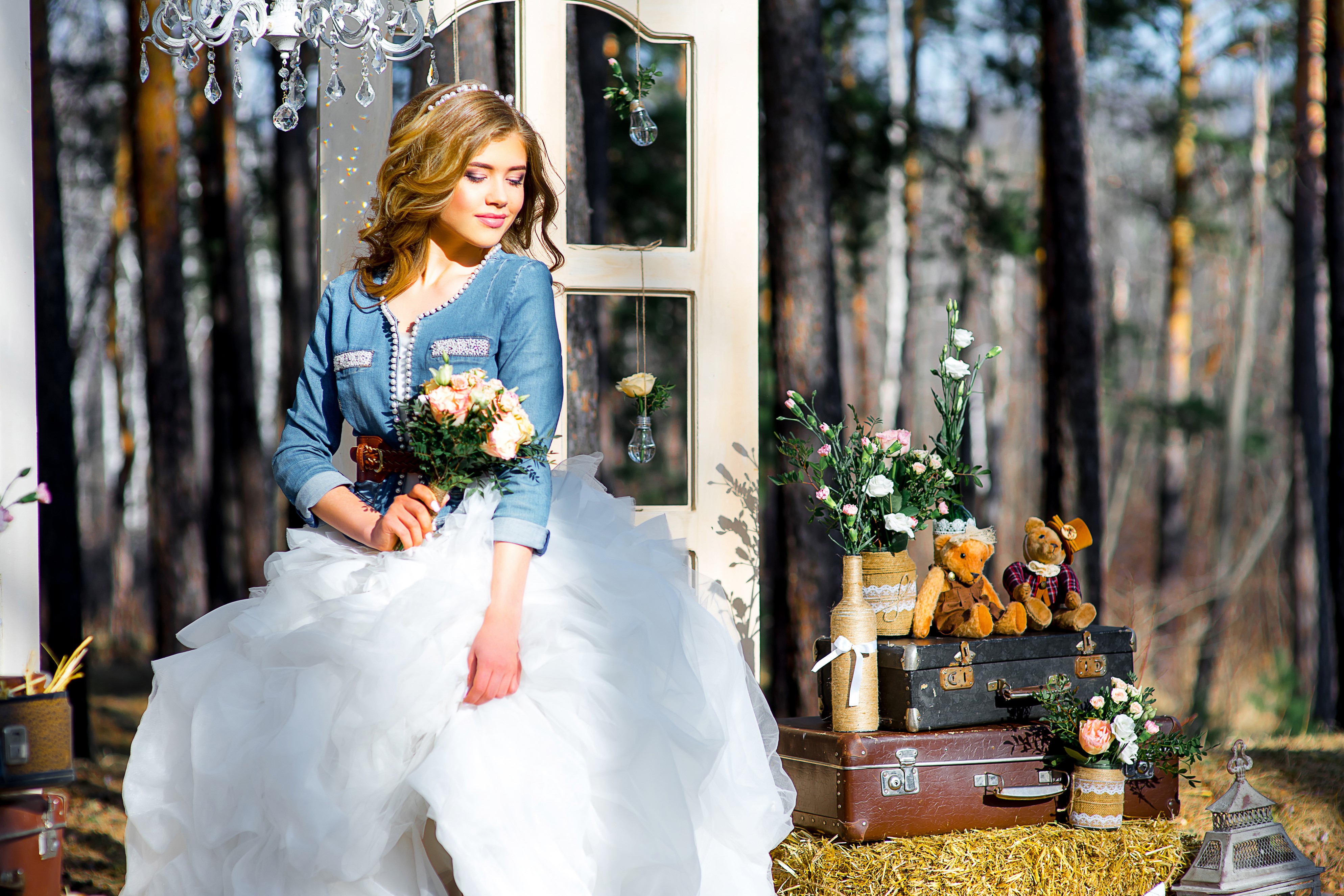 Bride in denim jacket holding bouquet with teddy bears and suitcases HD Wallpaper