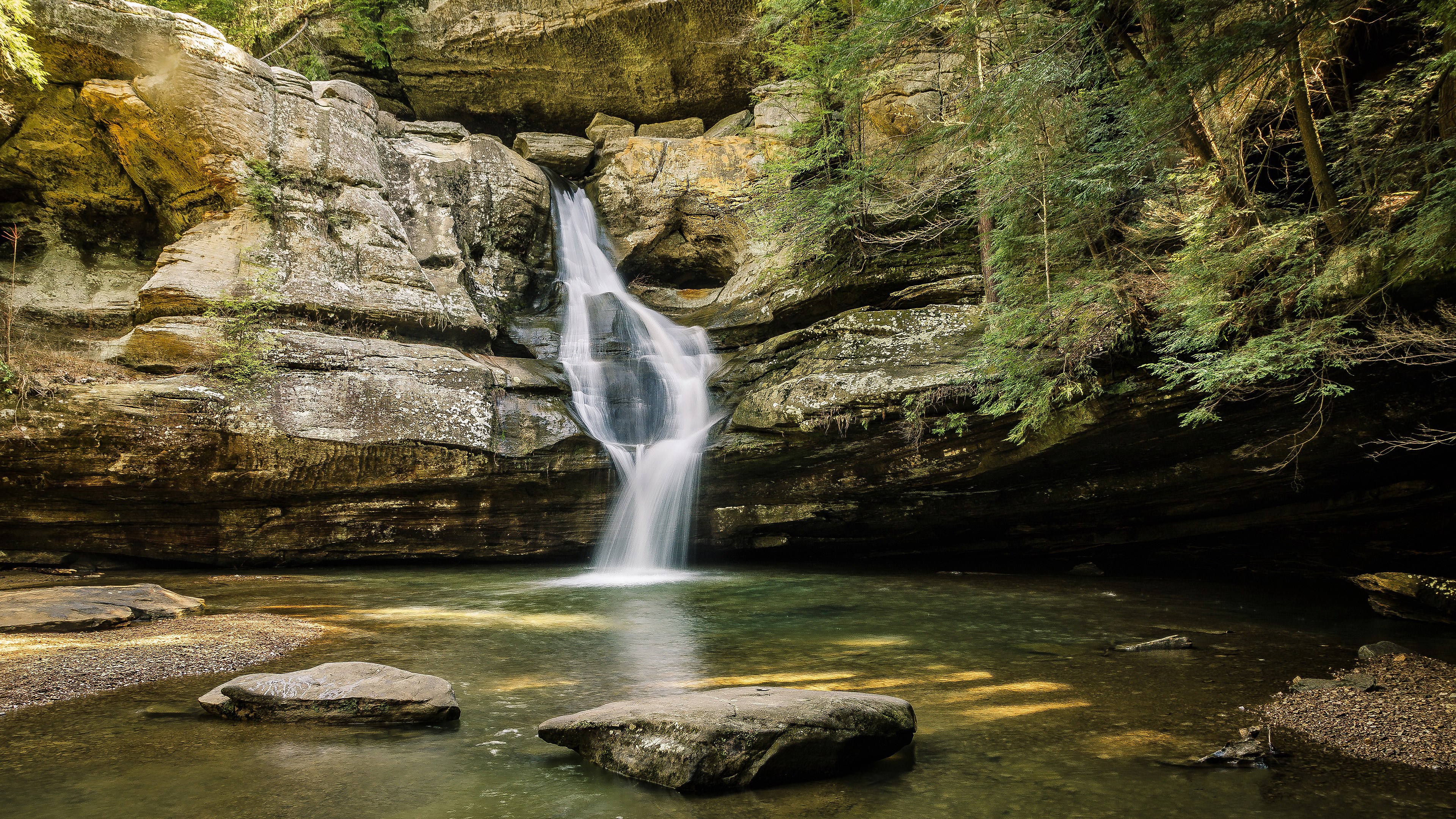 Waterfall cascading into a pool in a rocky gorge HD Wallpaper