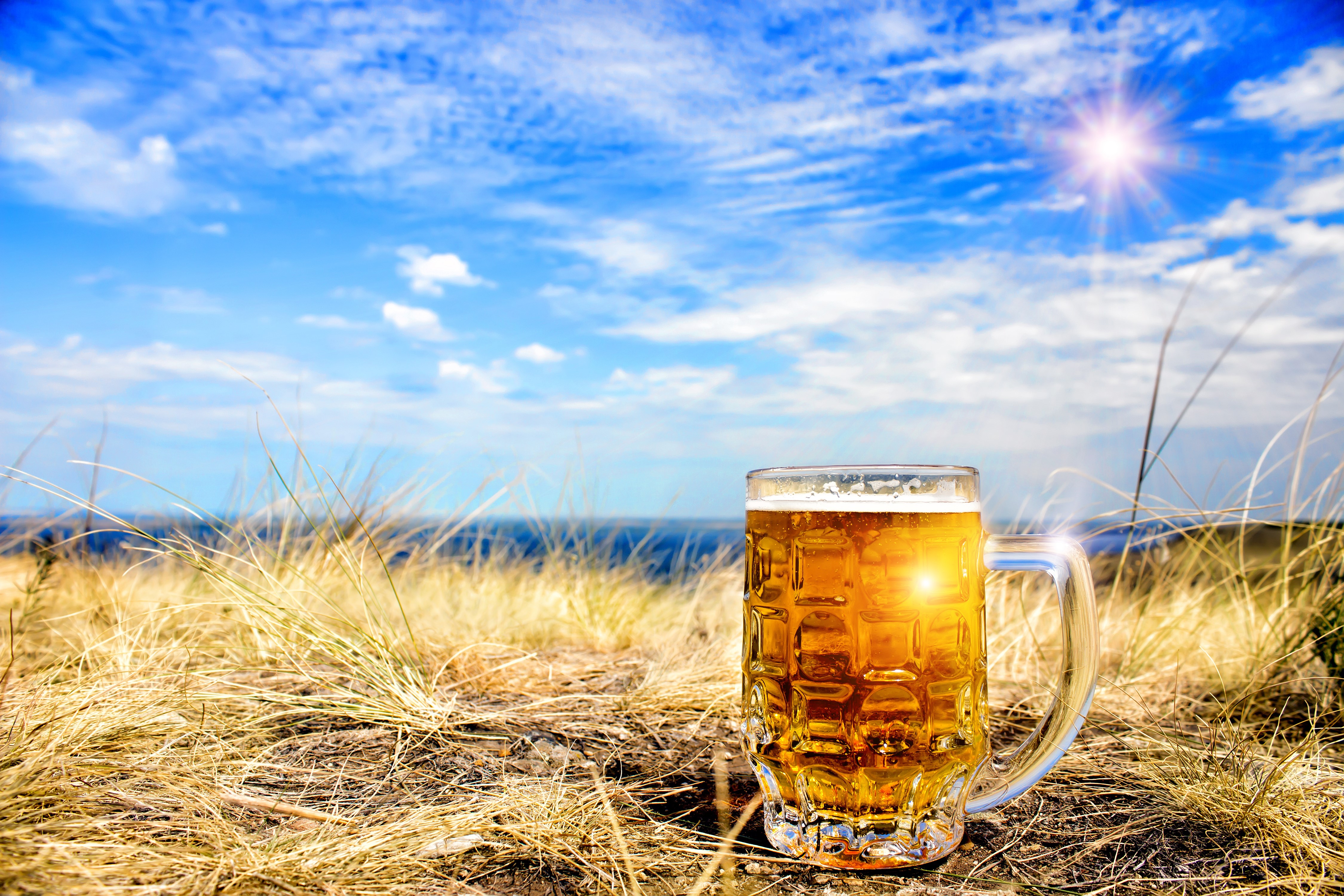 Beer mug on a beach with blue sky HD Wallpaper
