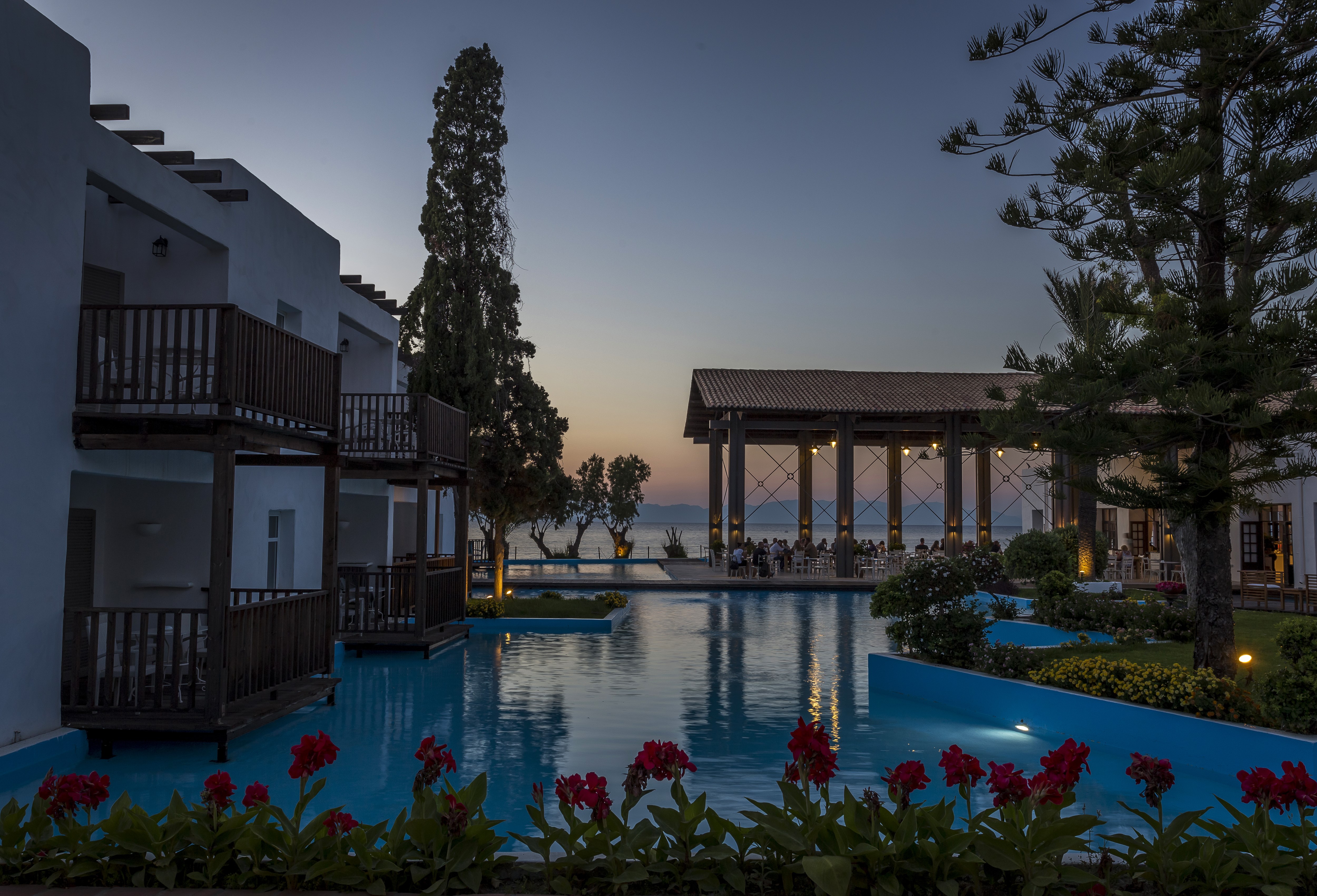 Resort with pool and sea view at dusk HD Wallpaper