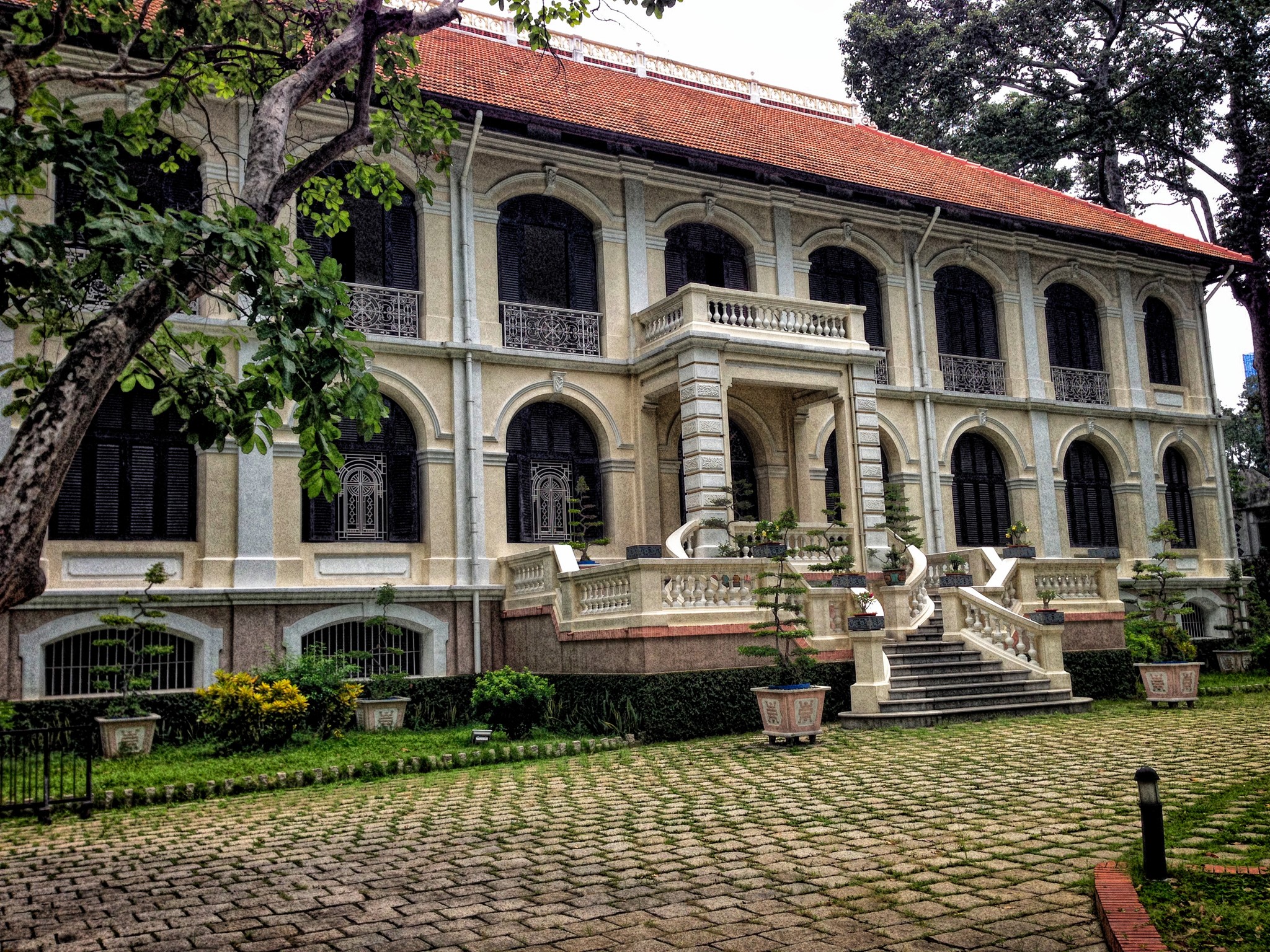 Colonial building with stairs and trees in Ho Chi Minh City, Vietnam HD Wallpaper