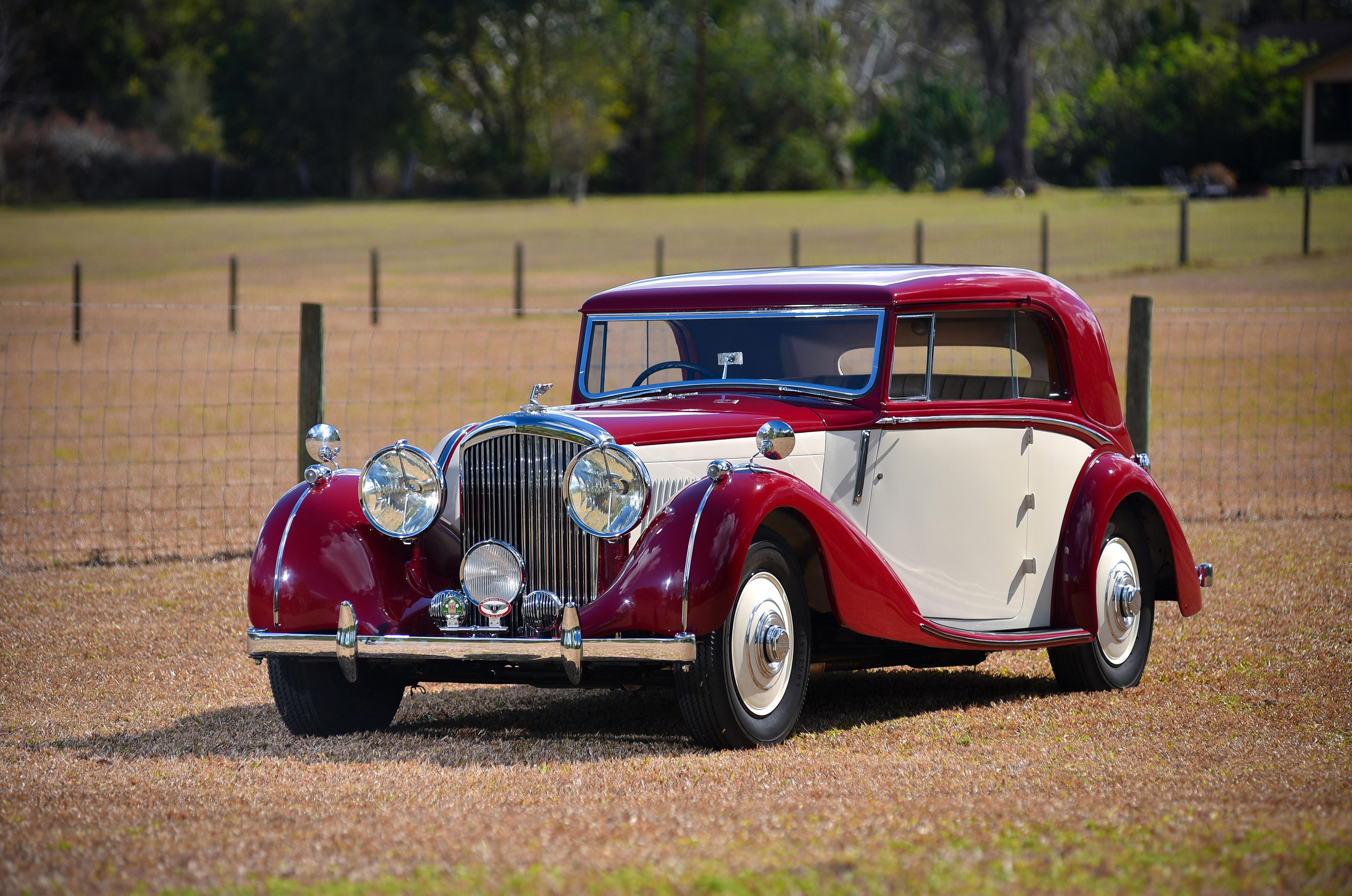 Two-tone red and cream Bentley parked on grass HD Wallpaper