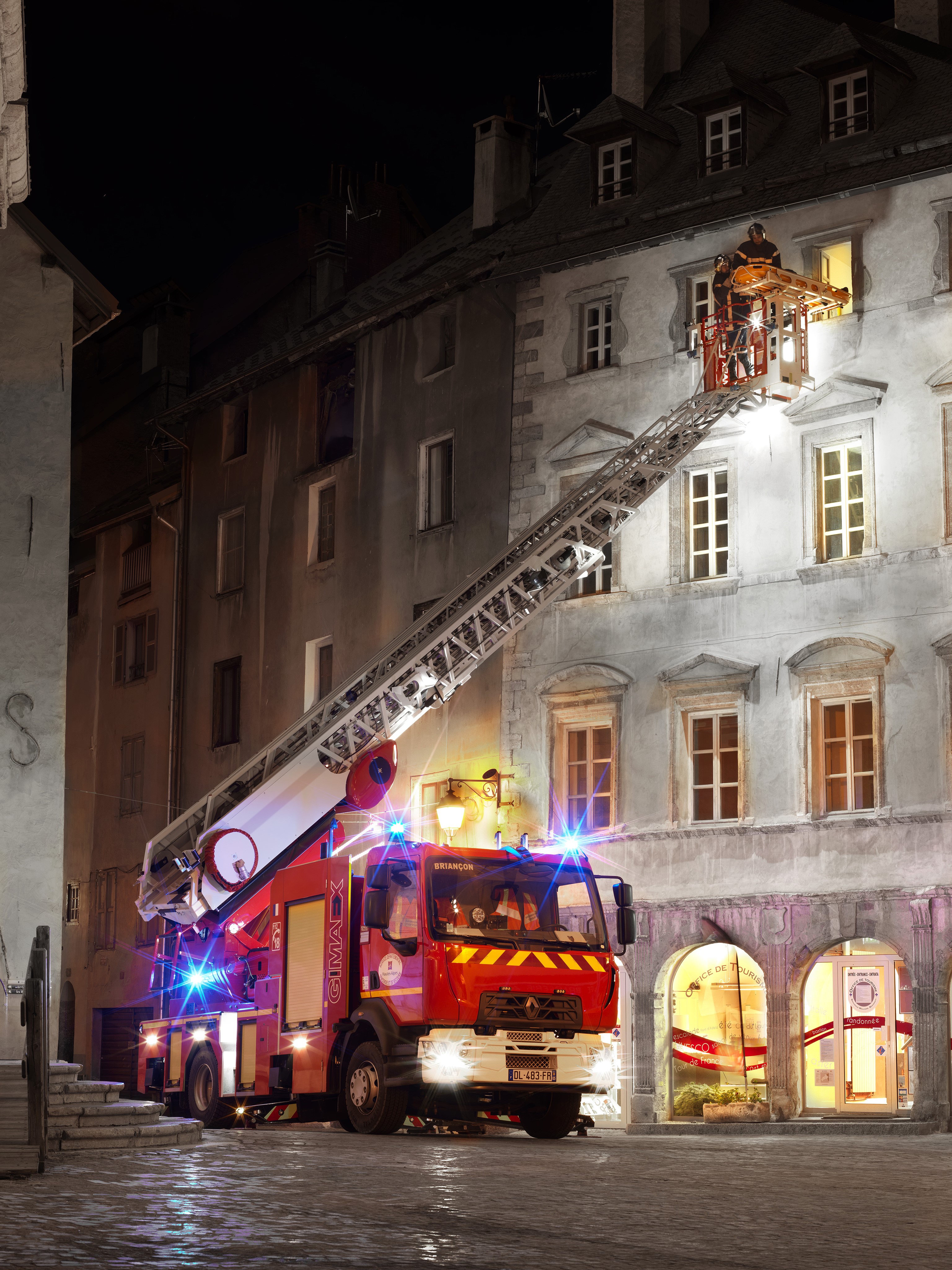 Fire engine with ladder at night in front of buildings HD Phone Wallpaper