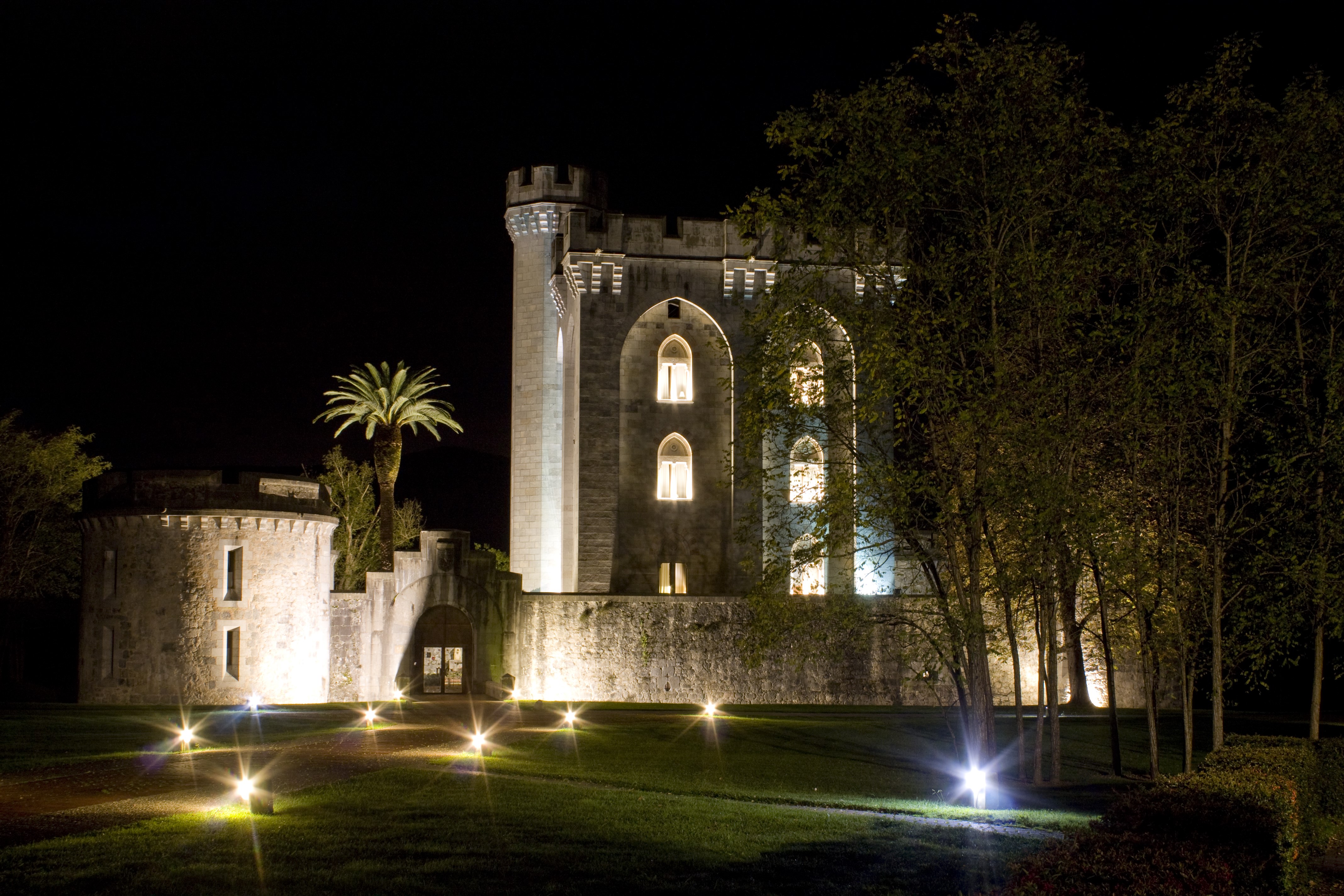 Castle at night with lawn and lights HD Wallpaper