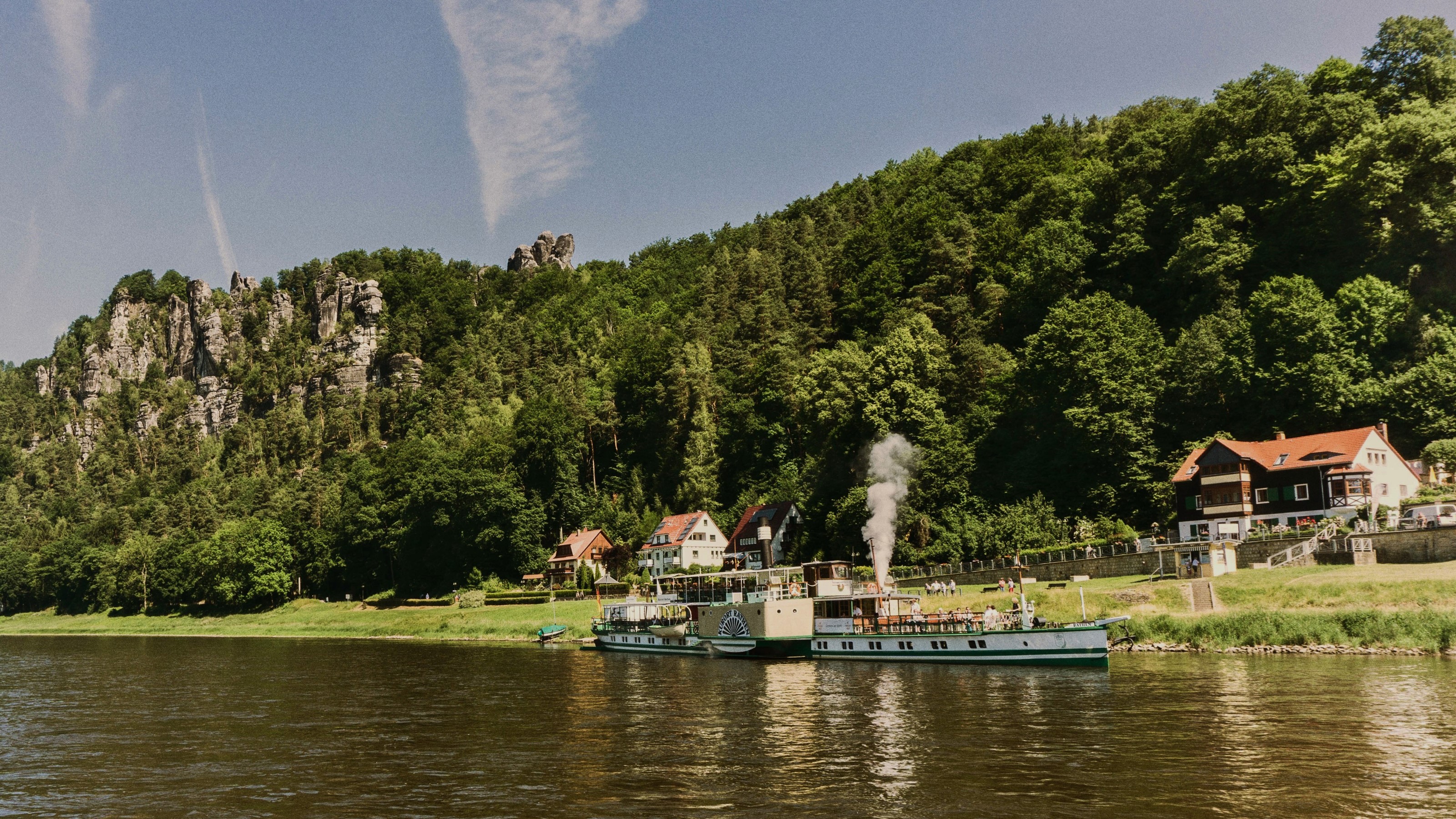 Riverboats docked by a forested cliffside in Rathen, Germany HD Wallpaper