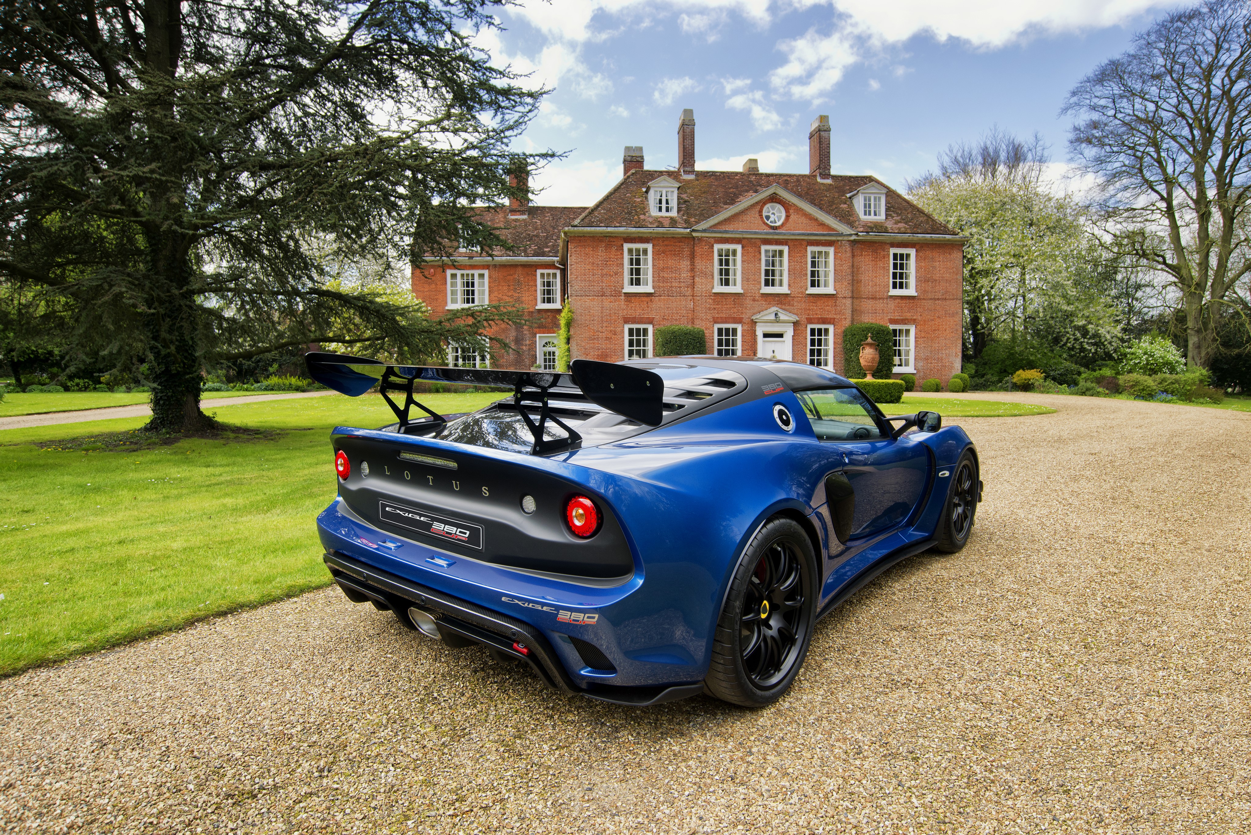 Blue Lotus Exige Cup 380 parked in front of a mansion HD Wallpaper
