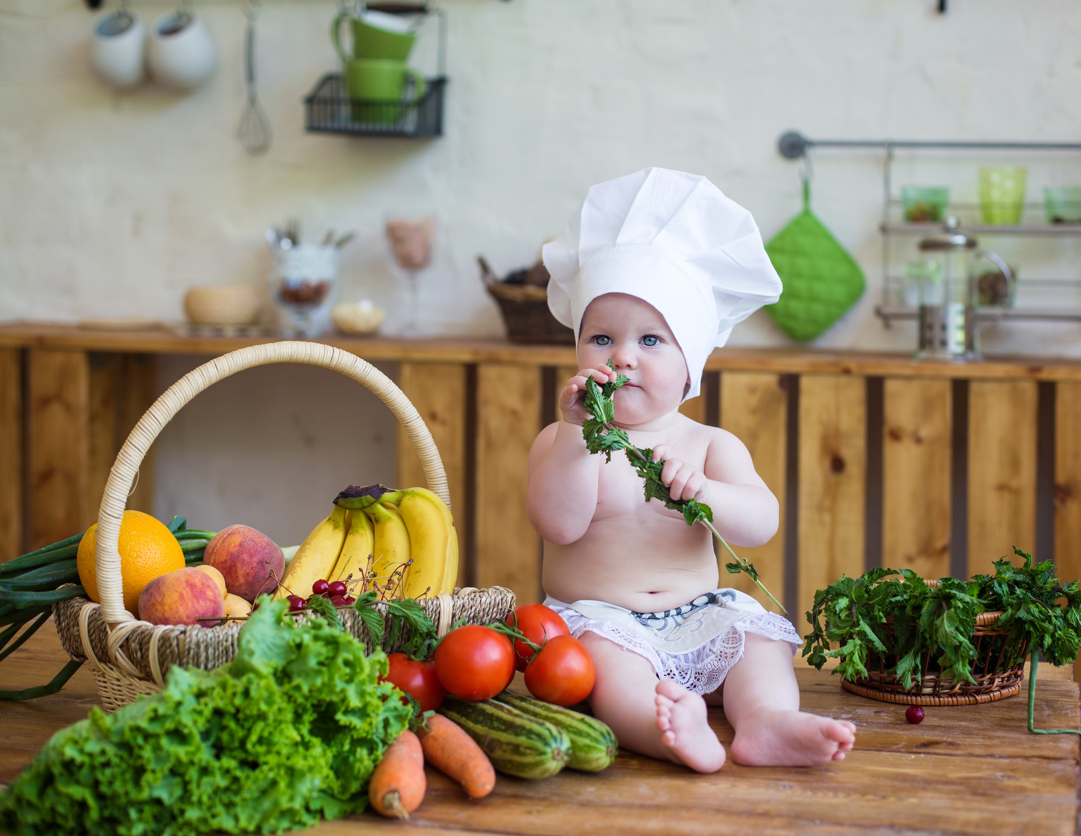 Baby in chef hat with basket of fruits and vegetables HD Wallpaper