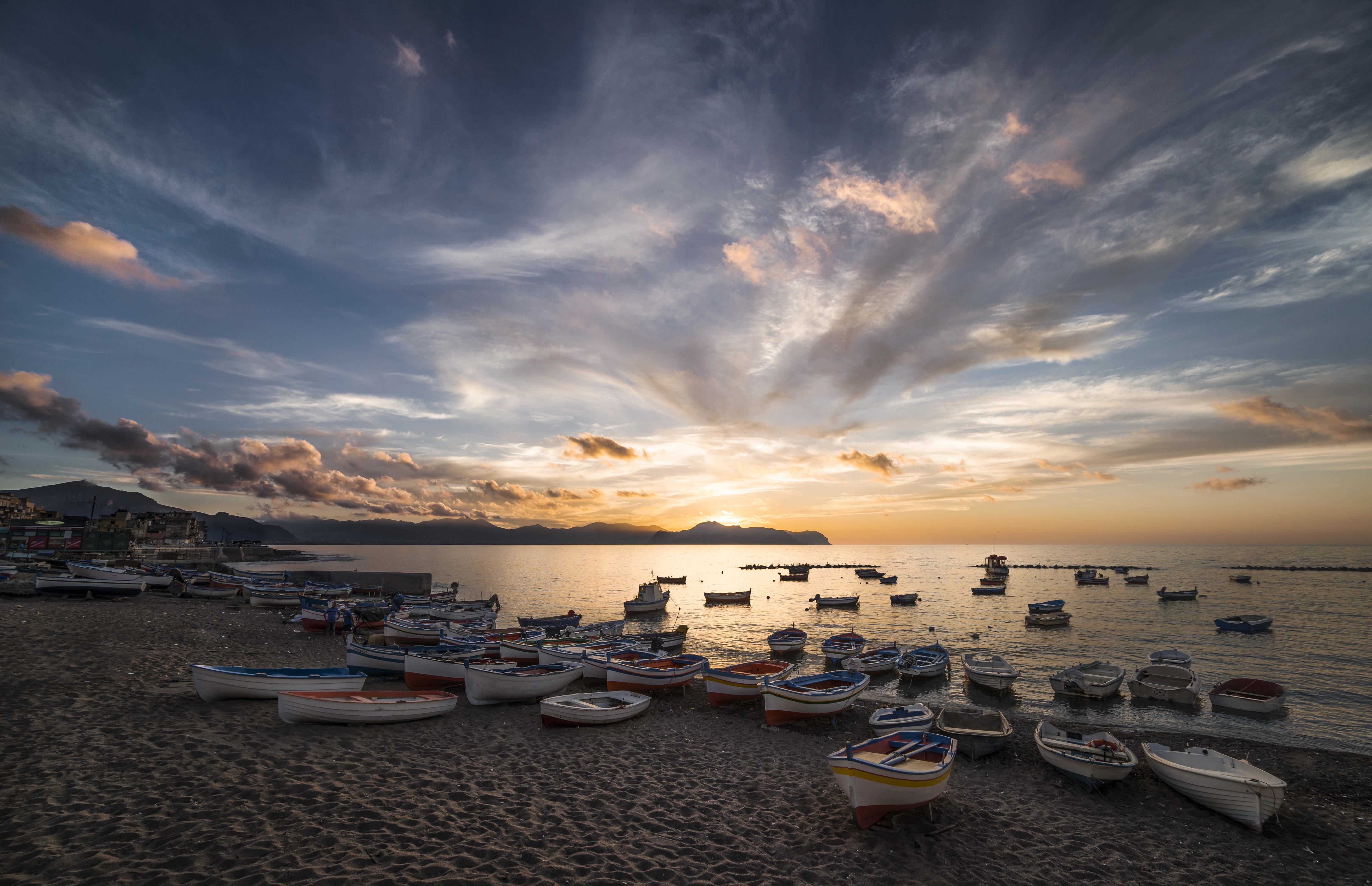 Boats on a beach at sunset with dramatic clouds HD Wallpaper