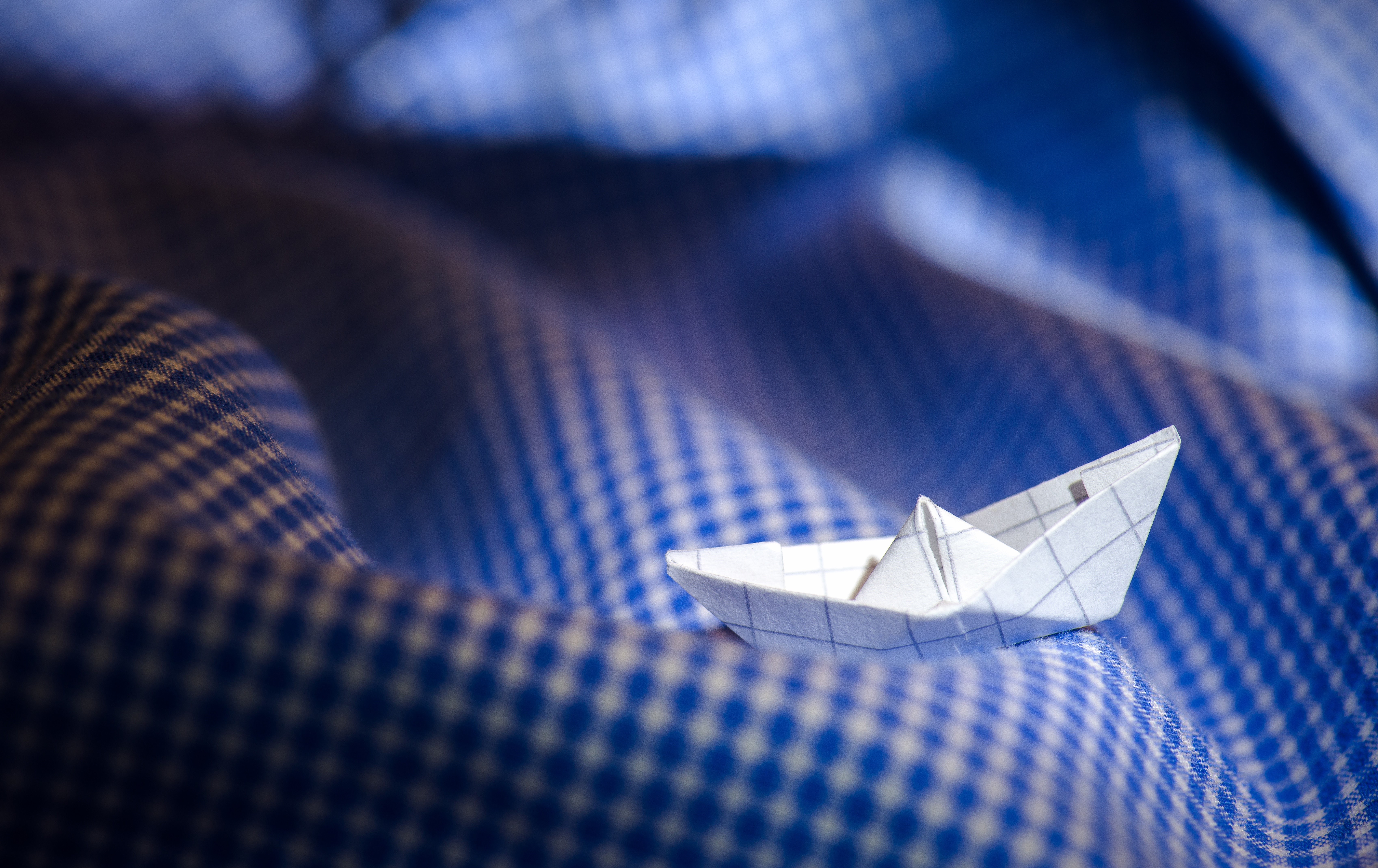 Origami paper boat on blue checkered fabric HD Wallpaper