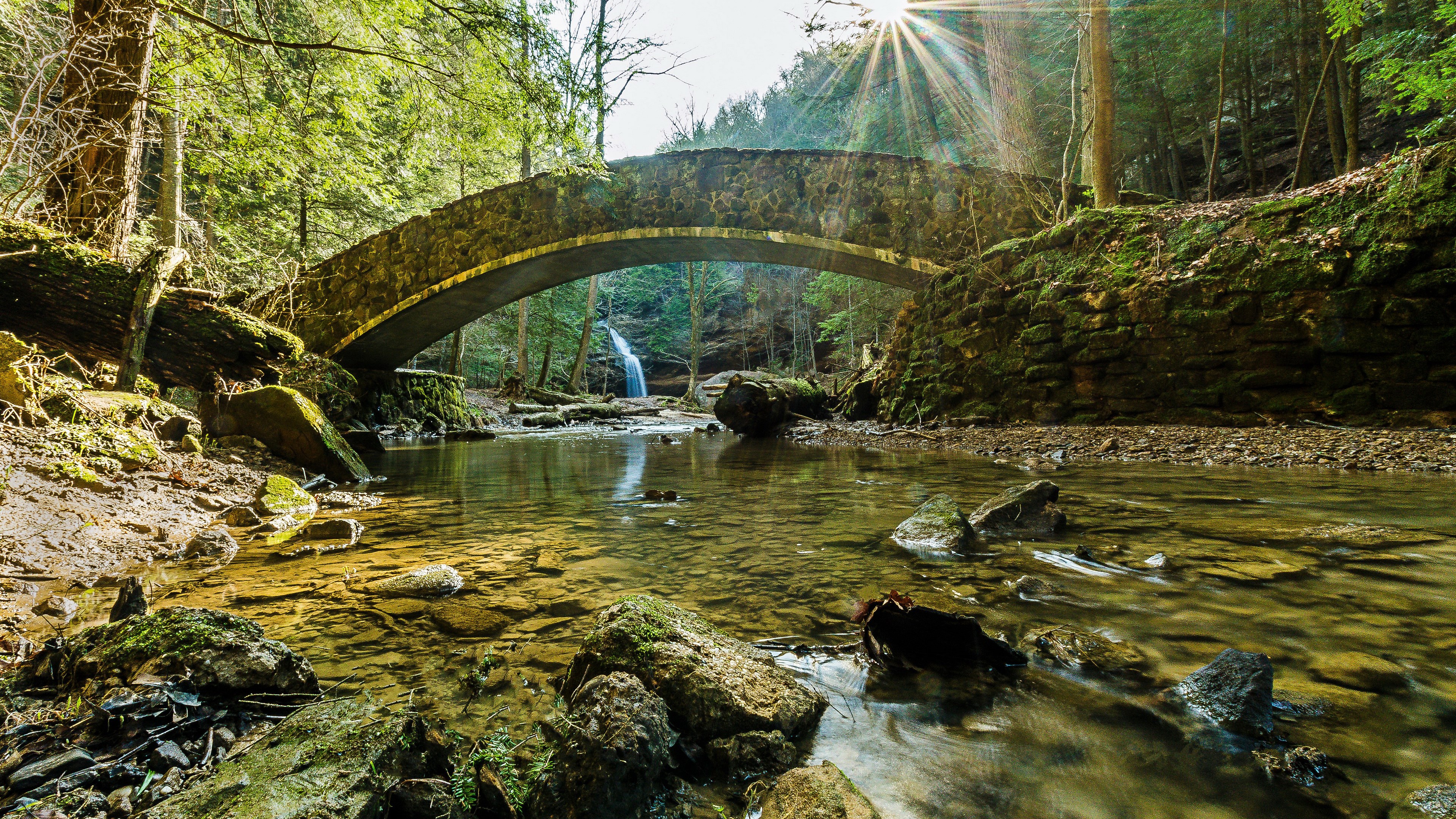 Stone bridge over a stream with a waterfall HD Wallpaper
