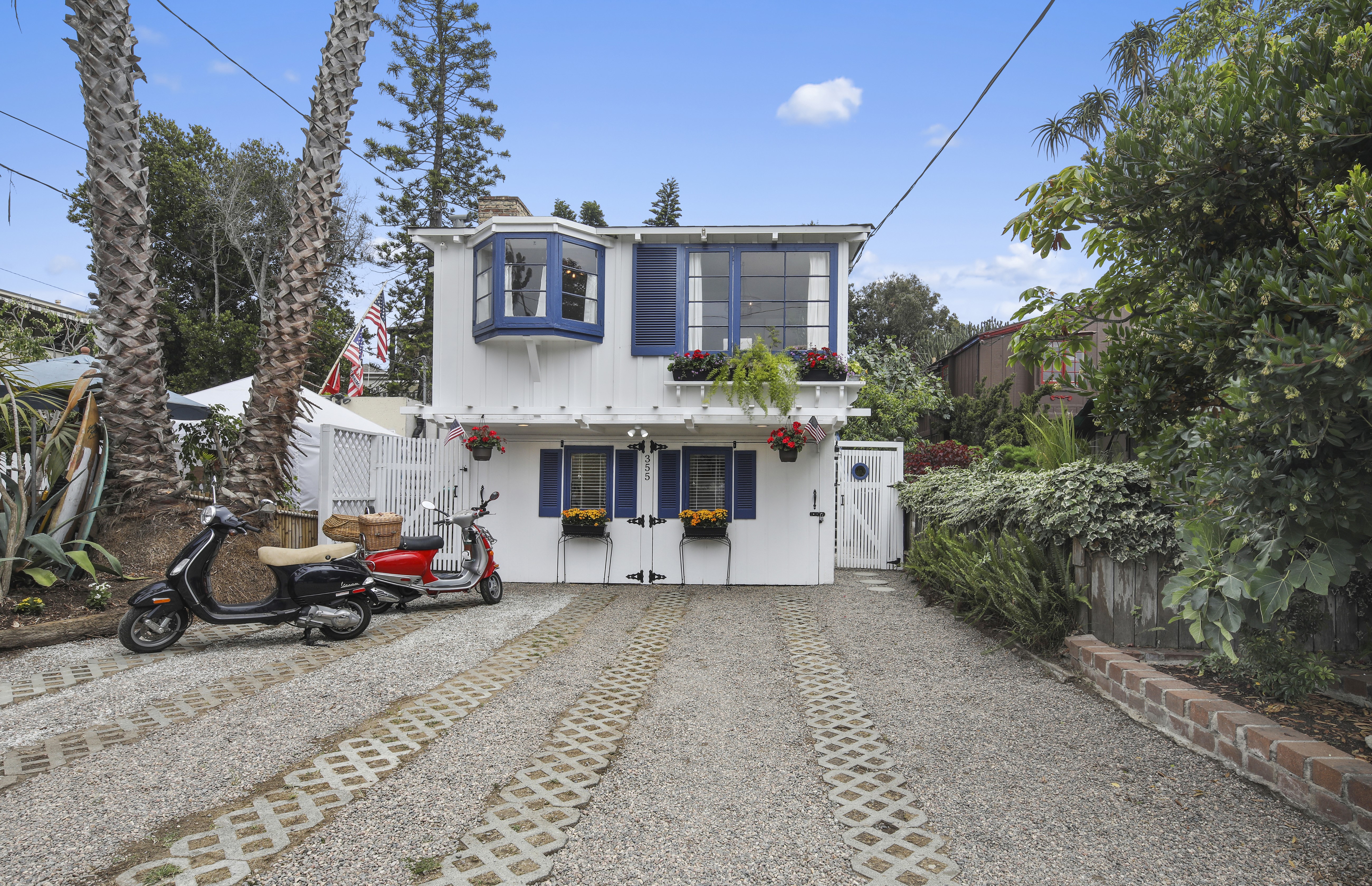White house with blue shutters and scooters in driveway HD Wallpaper