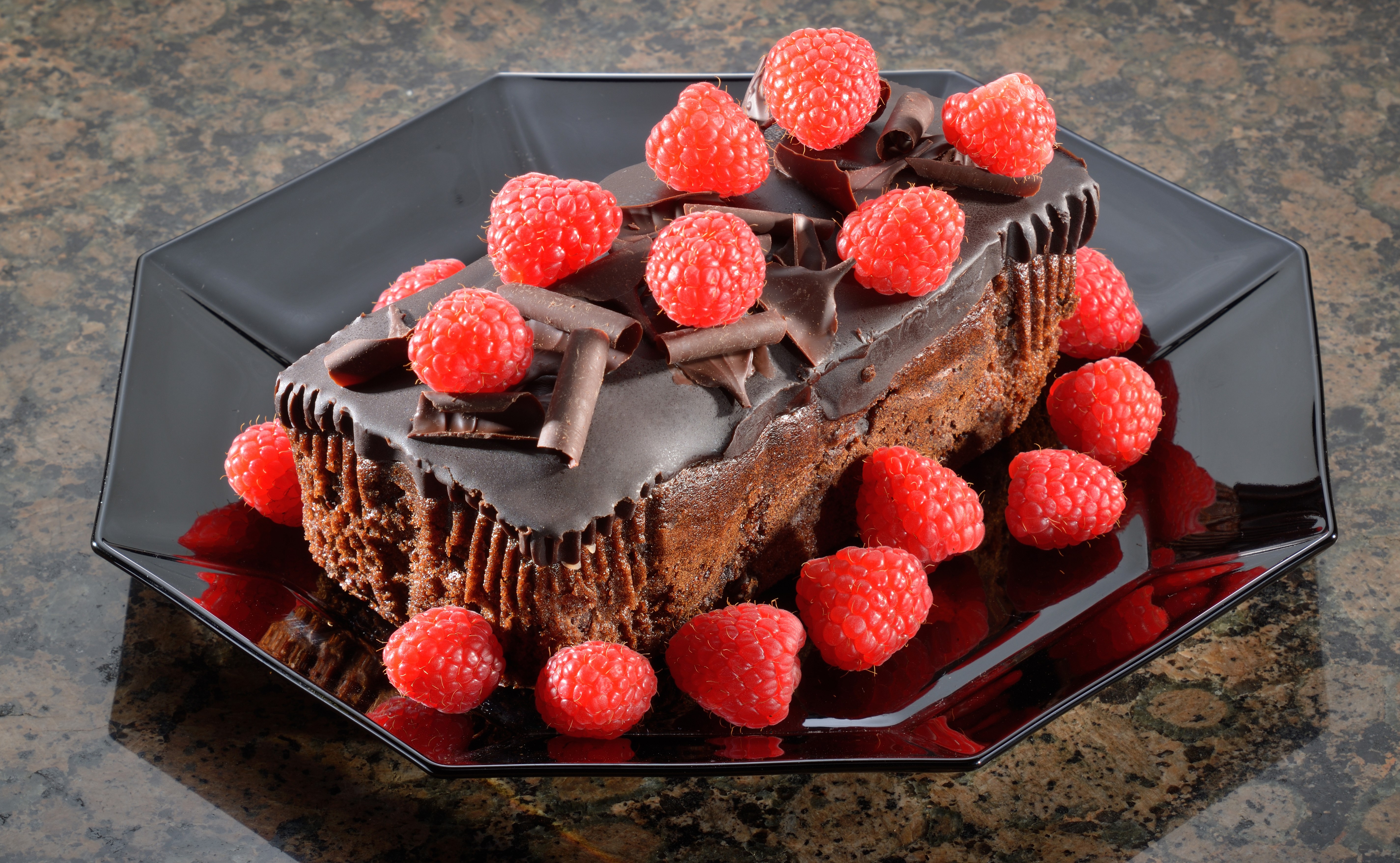 Chocolate cake with raspberries on a black plate HD Wallpaper