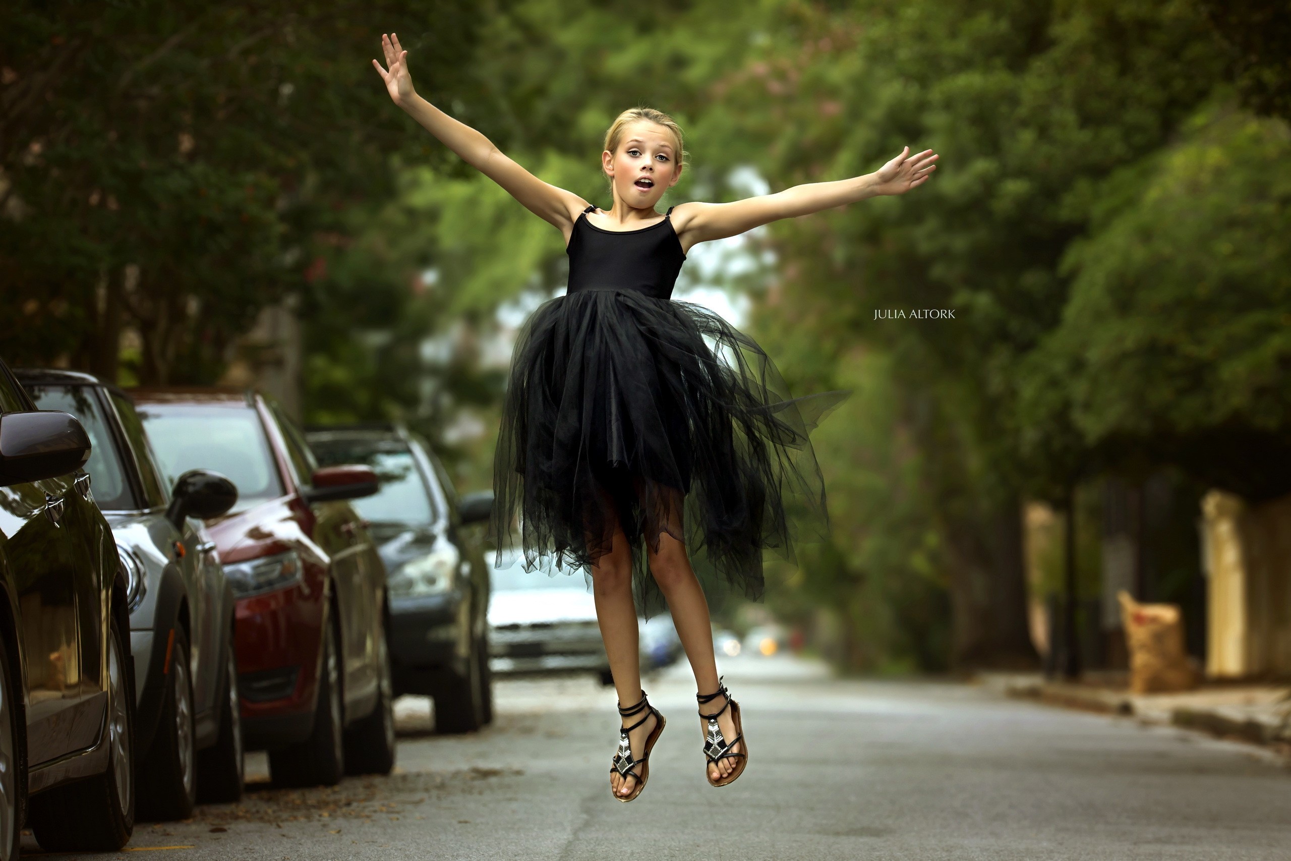 Little girl in black tutu jumping on street HD Wallpaper