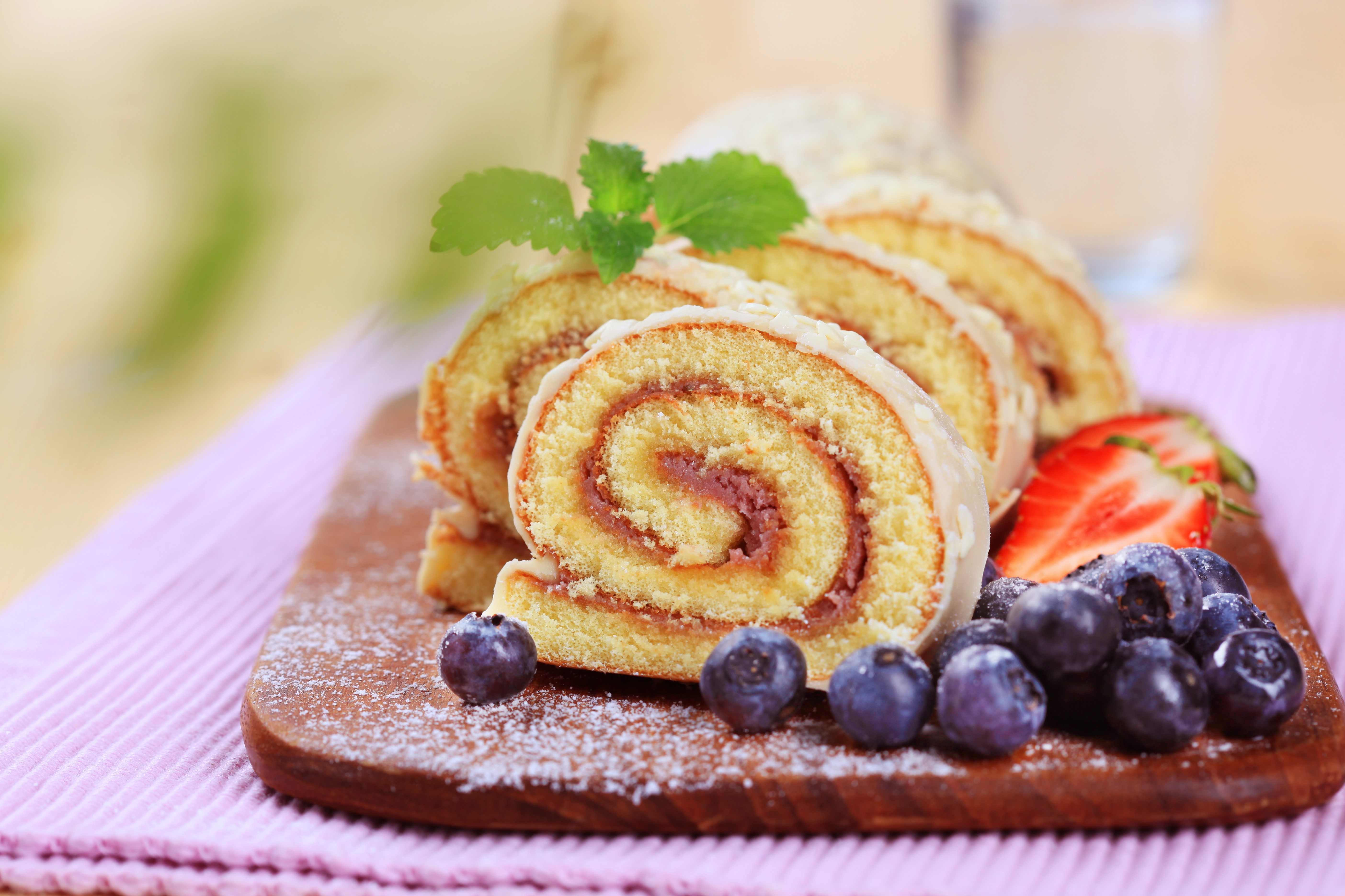 Swiss roll with berries on a cutting board HD Wallpaper