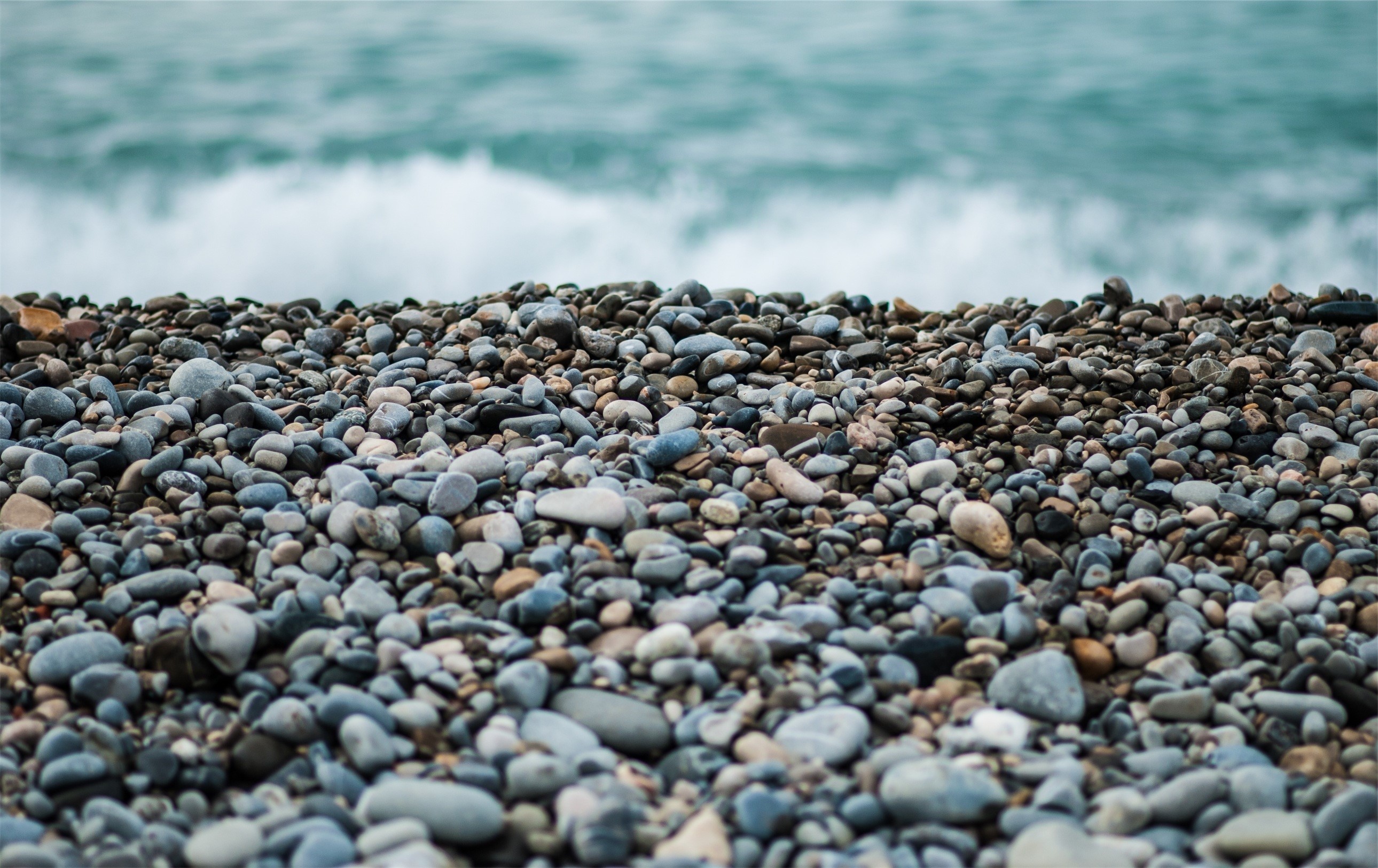 Pebble beach with ocean waves HD Wallpaper