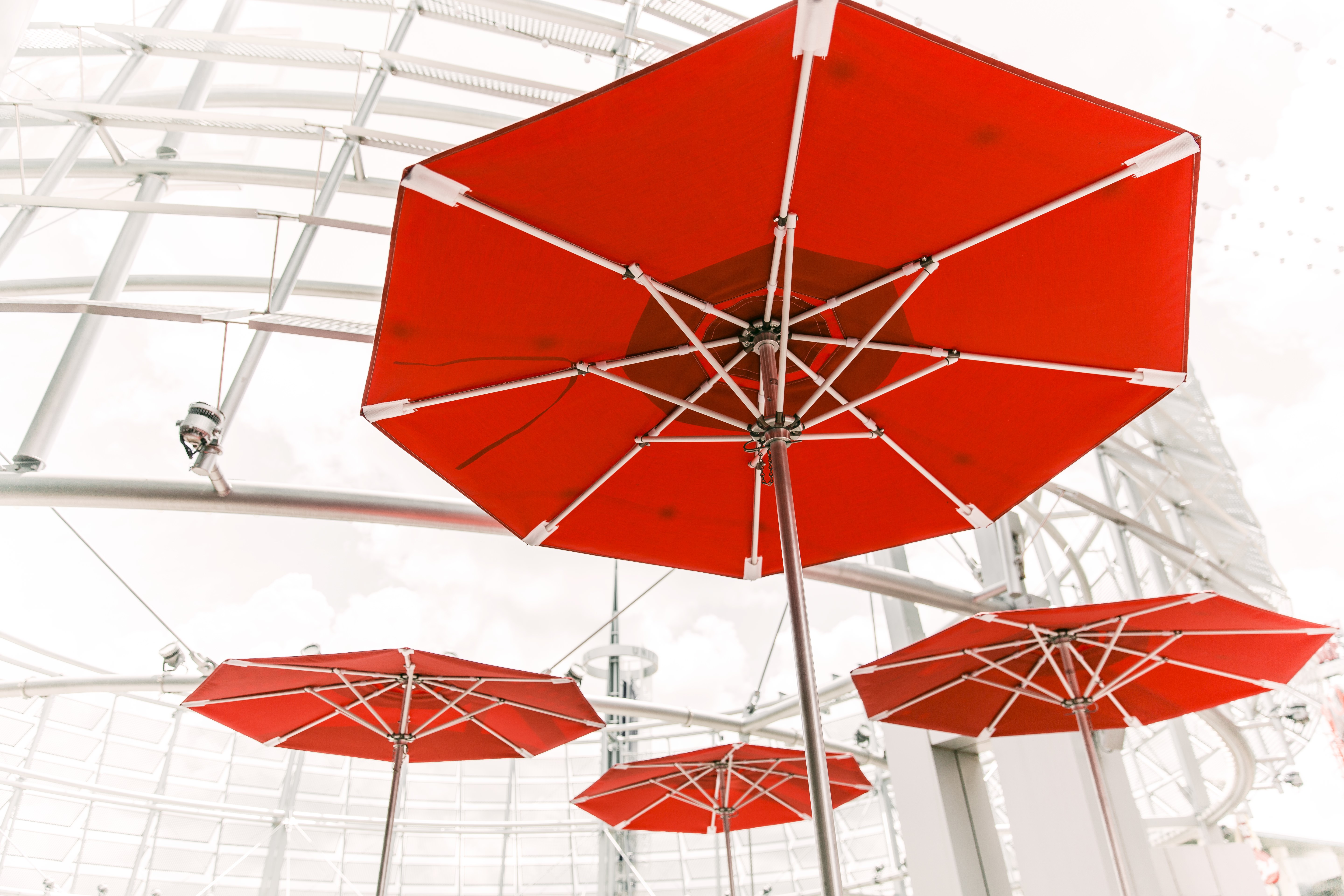 Red Umbrellas Under a Modern Structure HD Wallpaper