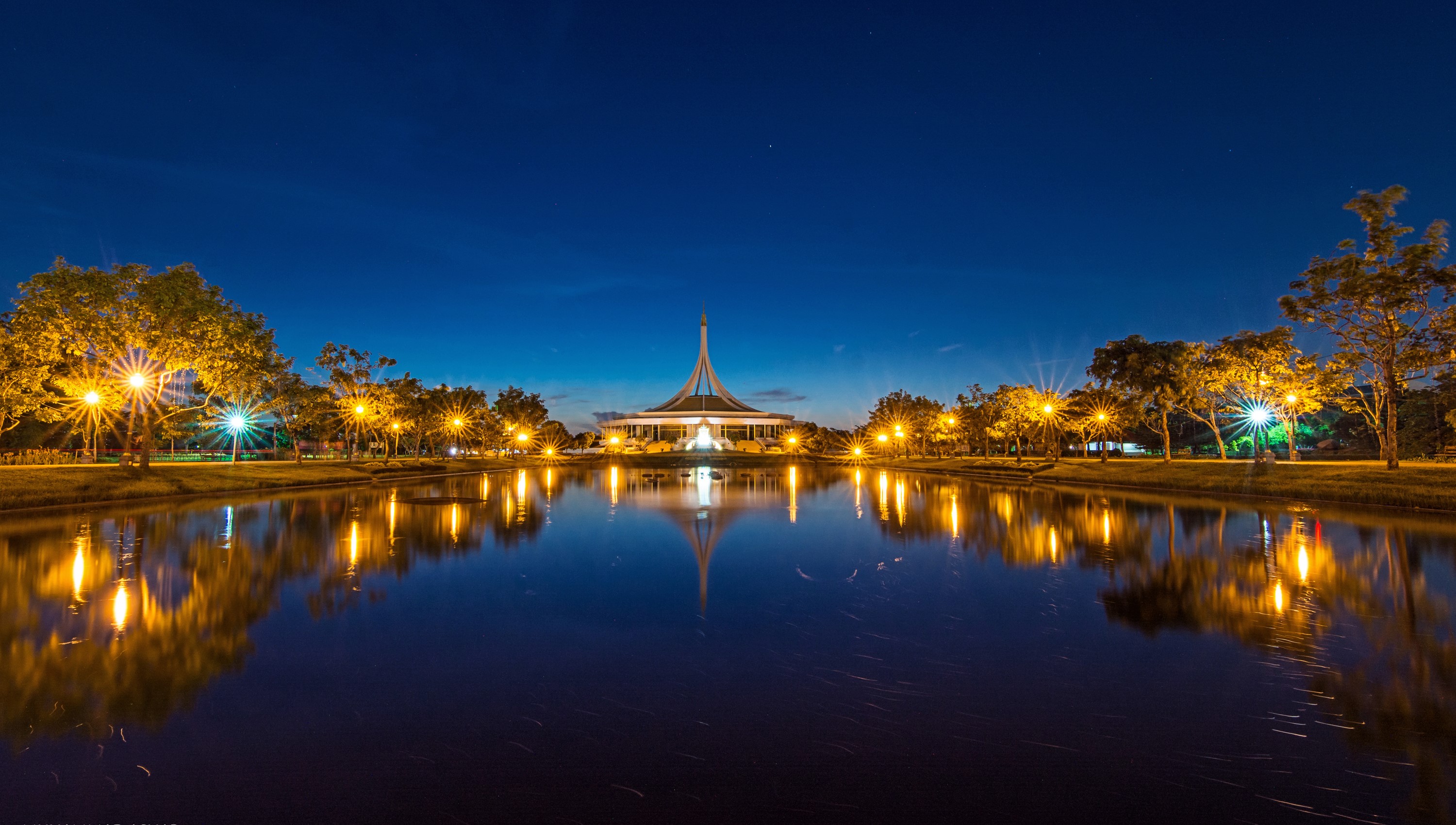 Park building reflected in pond at night with street lights HD Wallpaper