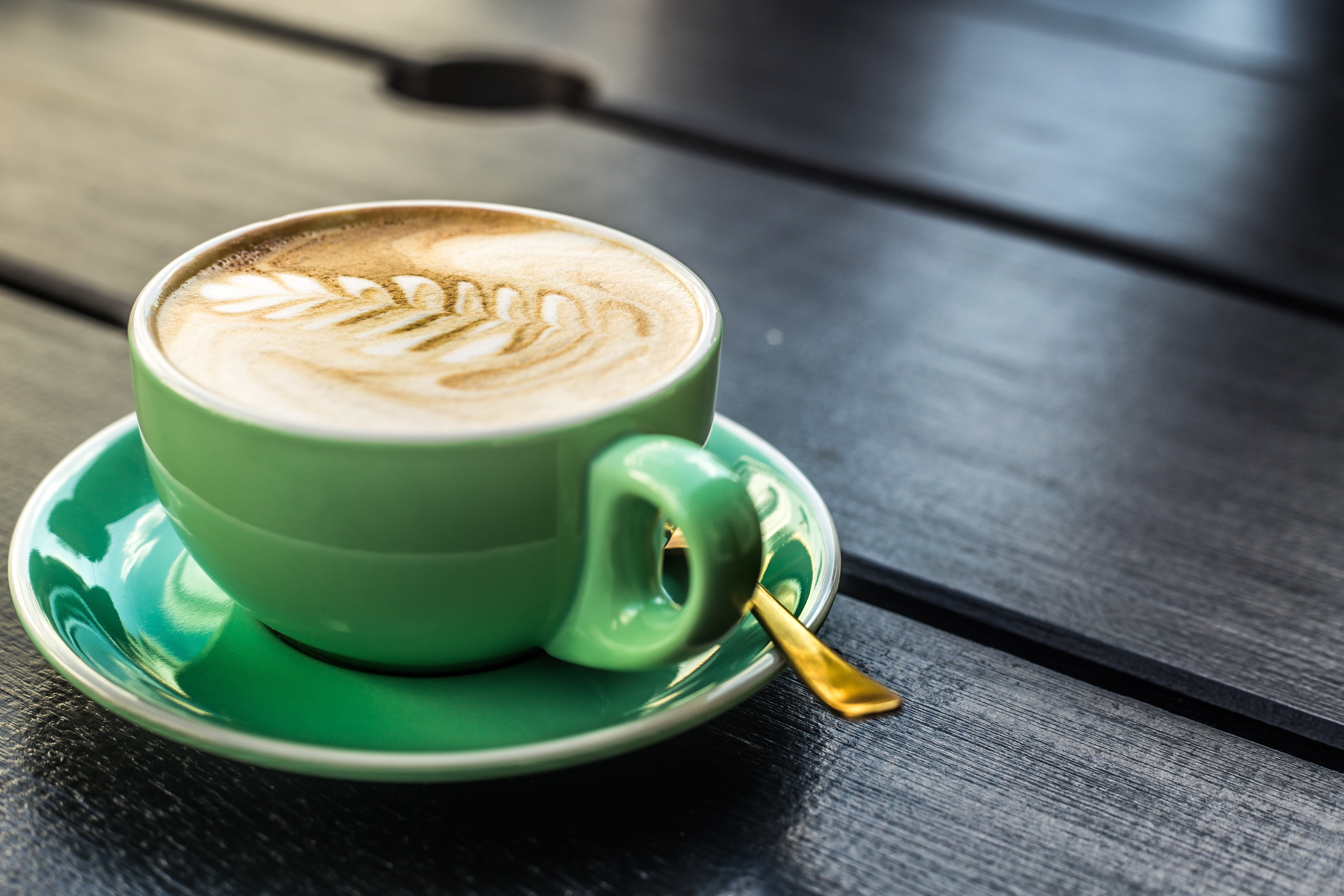 Cappuccino in a green cup with latte art HD Wallpaper